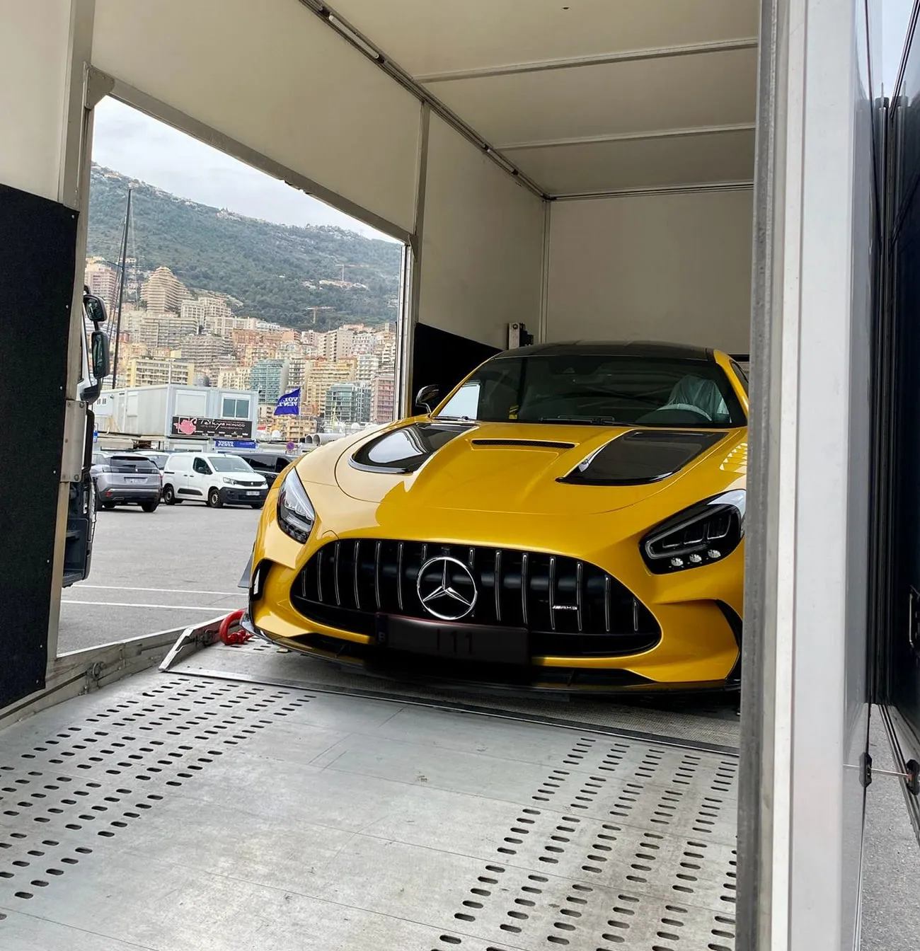Voorzijde van een gele AMG GT Black Series in een gesloten trailer