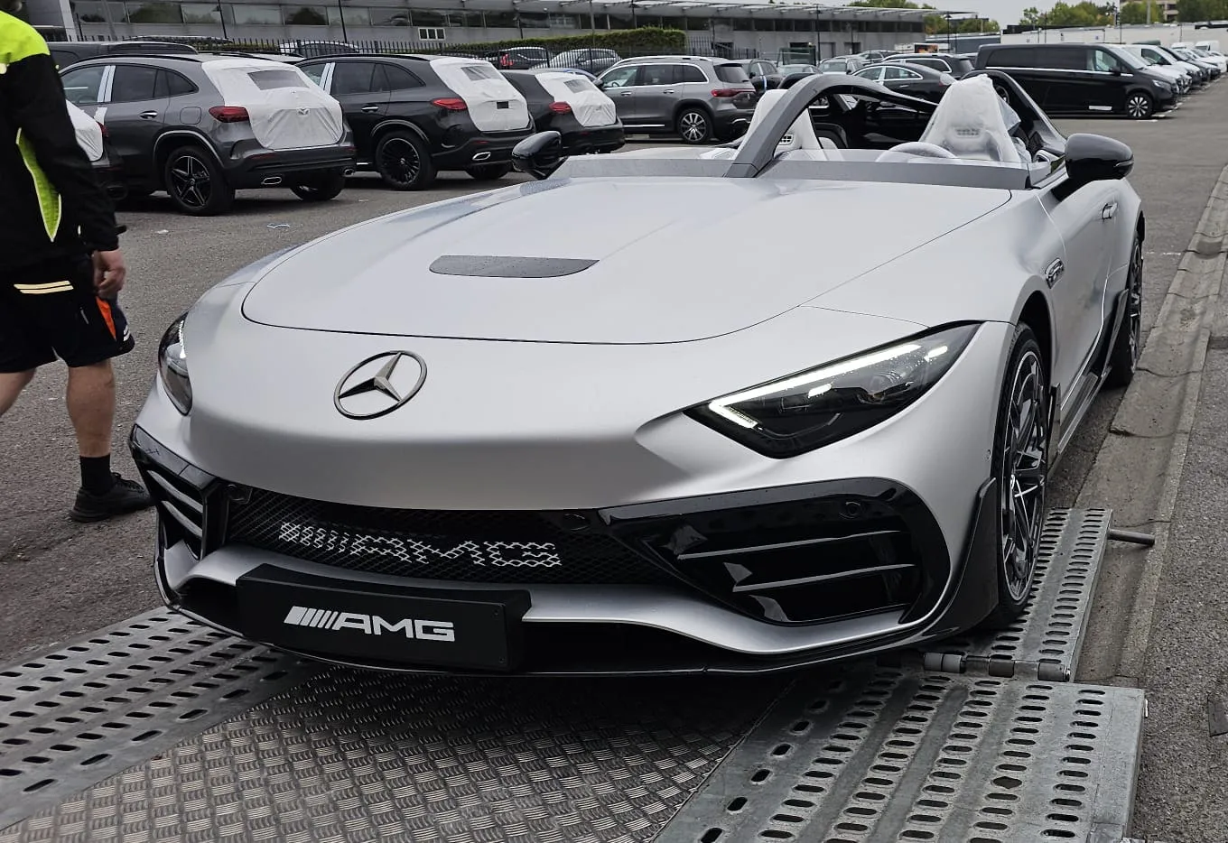 Zilveren Mercedes-AMG speedster zonder ruit die de kleppen op rijdt