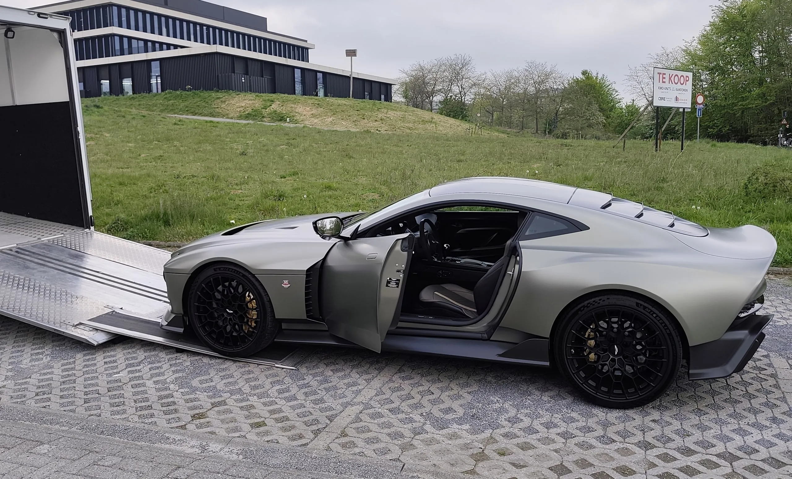Aston Martin Valour im Profil mit offener Tür am Fuß der Rampe
