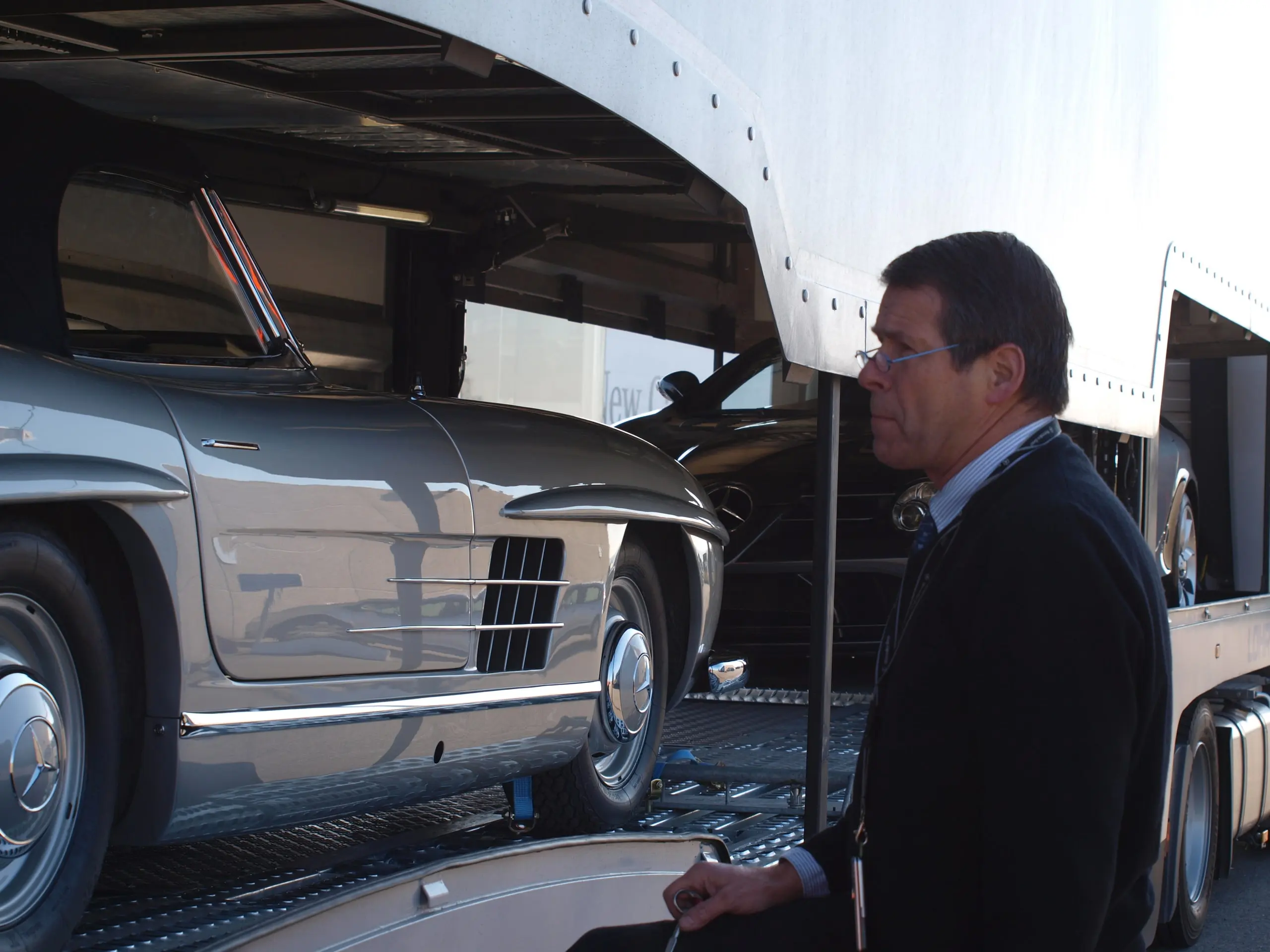Hombre de pie junto a un Mercedes 300 SL Alas de Gaviota antes de la descarga