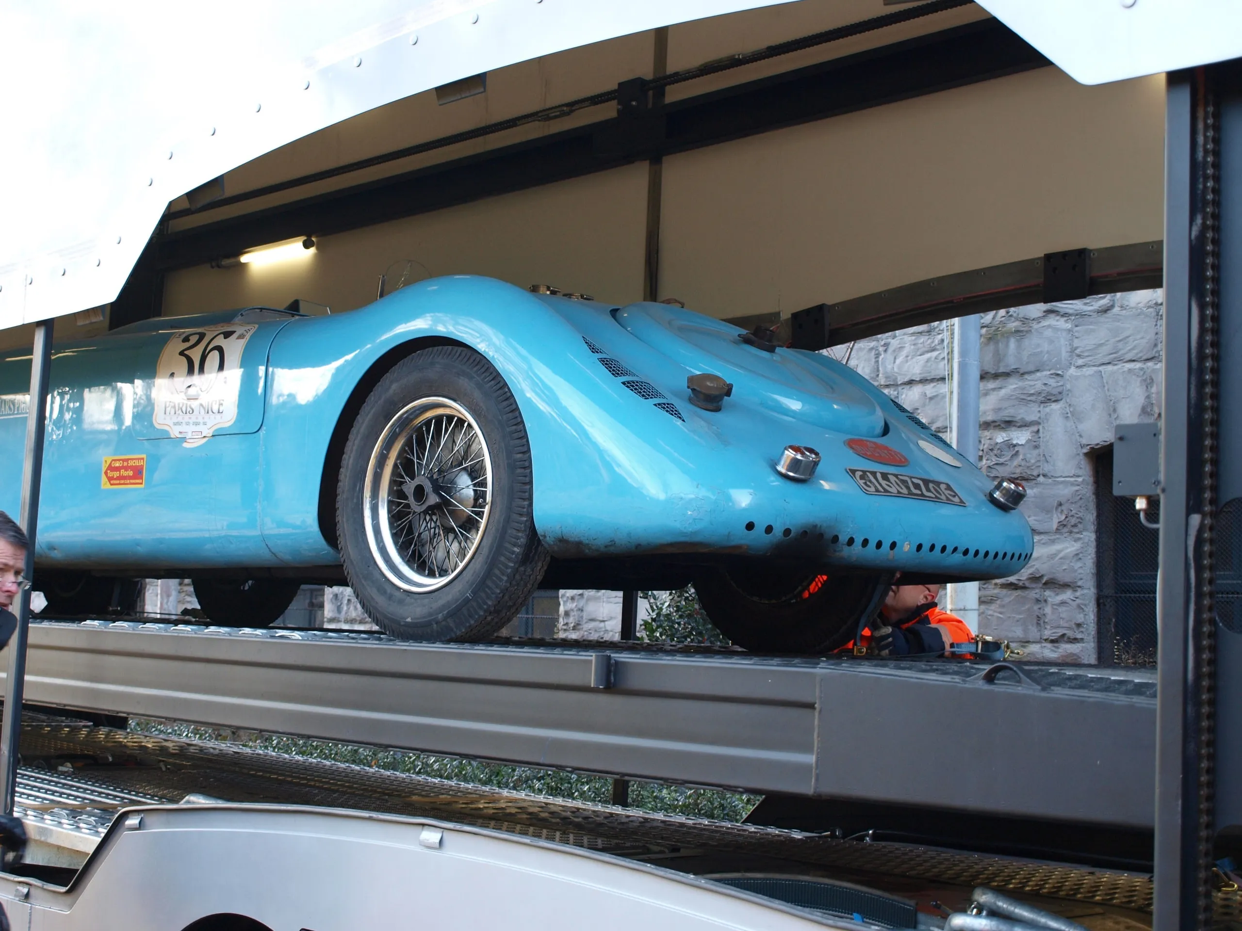 Blauwe gestroomlijnde vooroorlogse Bugatti-racewagen met startnummer op het dek