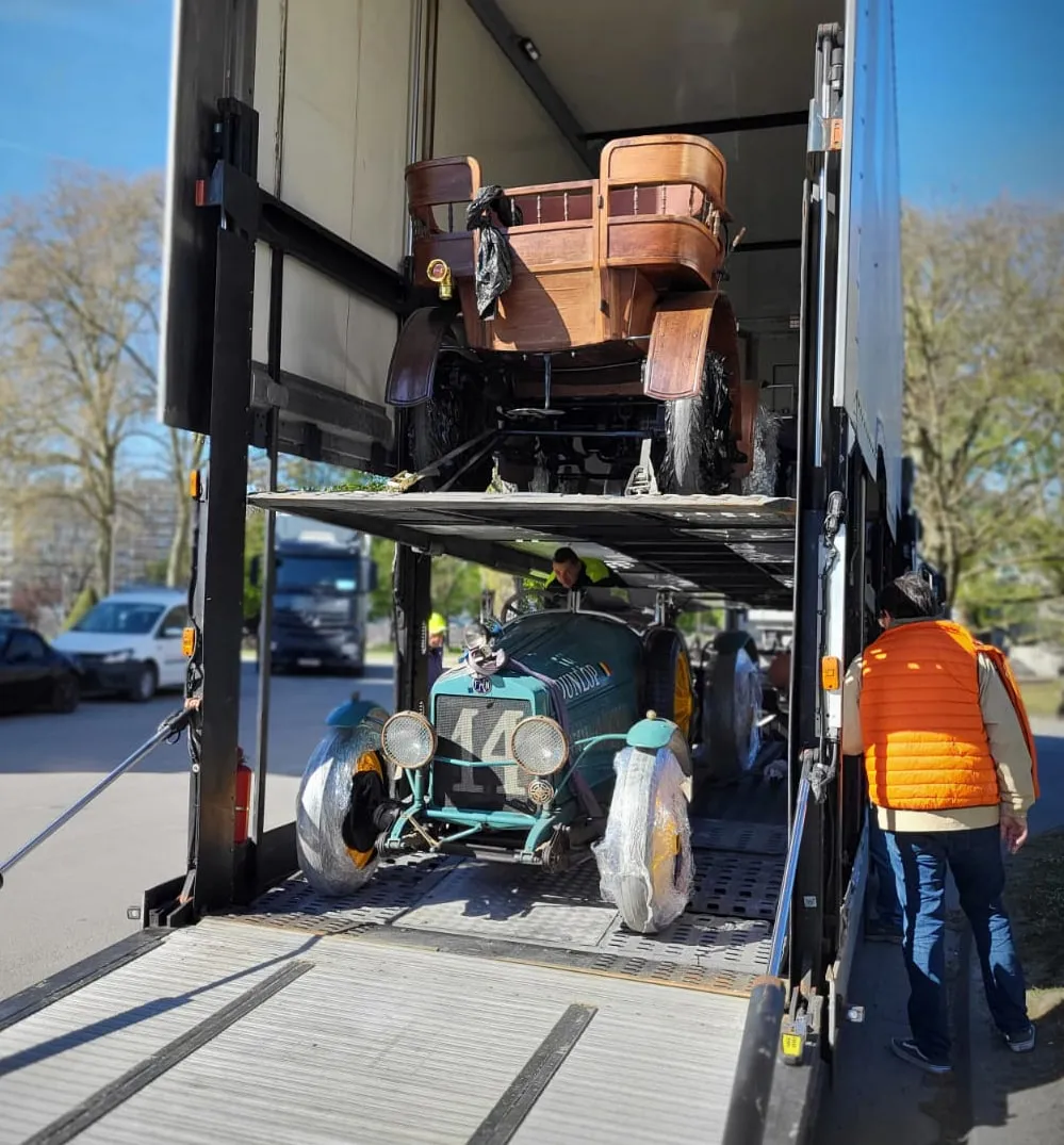 Automobiel uit de brass era op het bovendek van een autotransporter