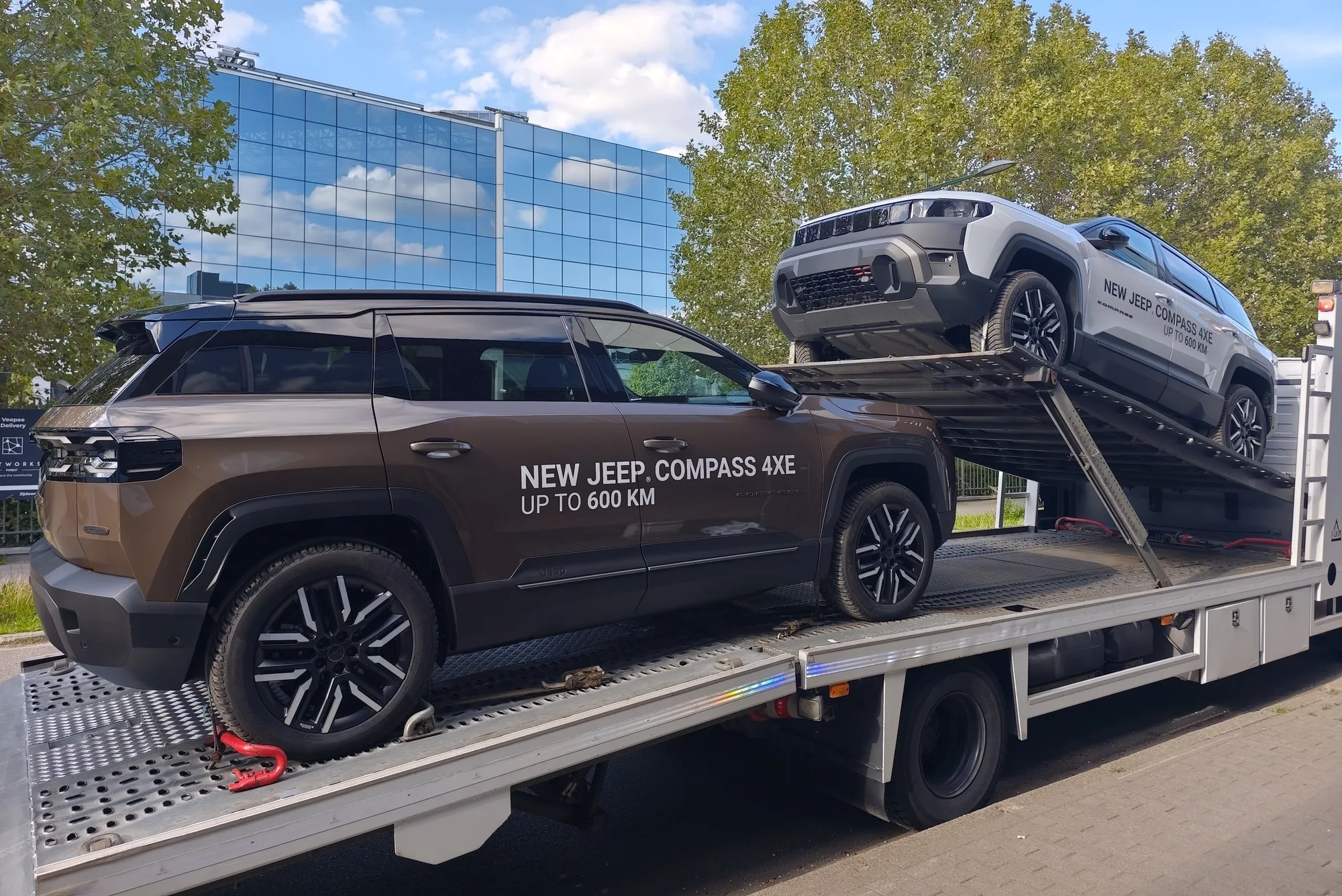 Jeep Compass 4xe marrón en la plataforma, uno gris claro en el nivel inclinado encima