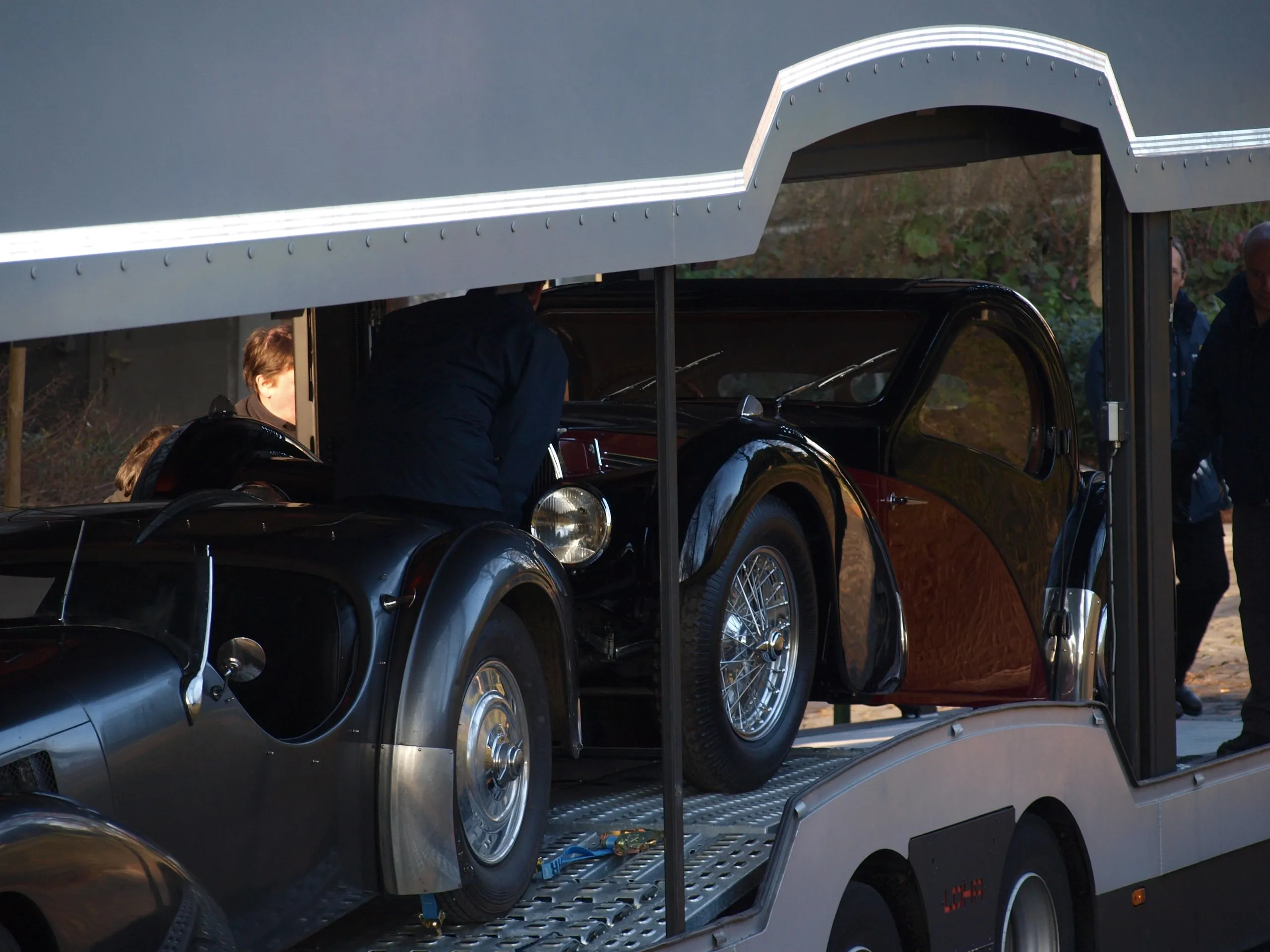 Vooroorlogse Bugatti-coupé in de open transporter, ploeg en toeschouwers eromheen