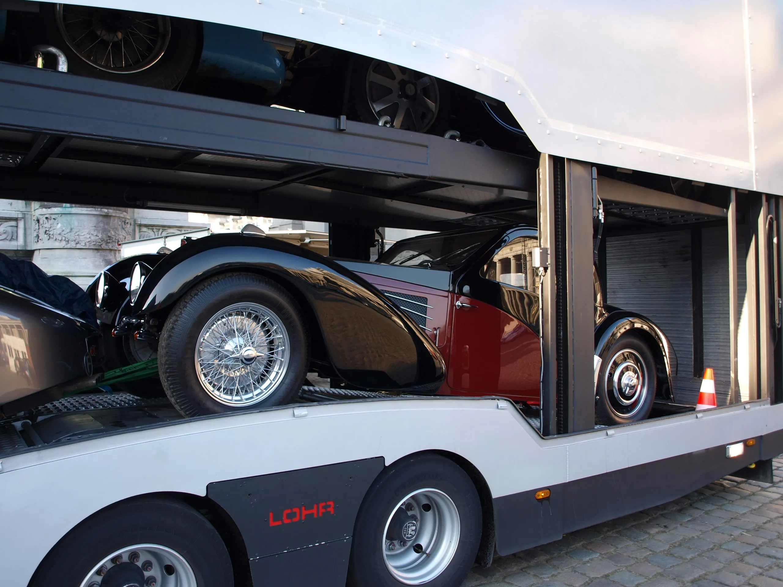 Vooroorlogse Bugatti-coupé op het dek, zijdeuren open, de boog erachter