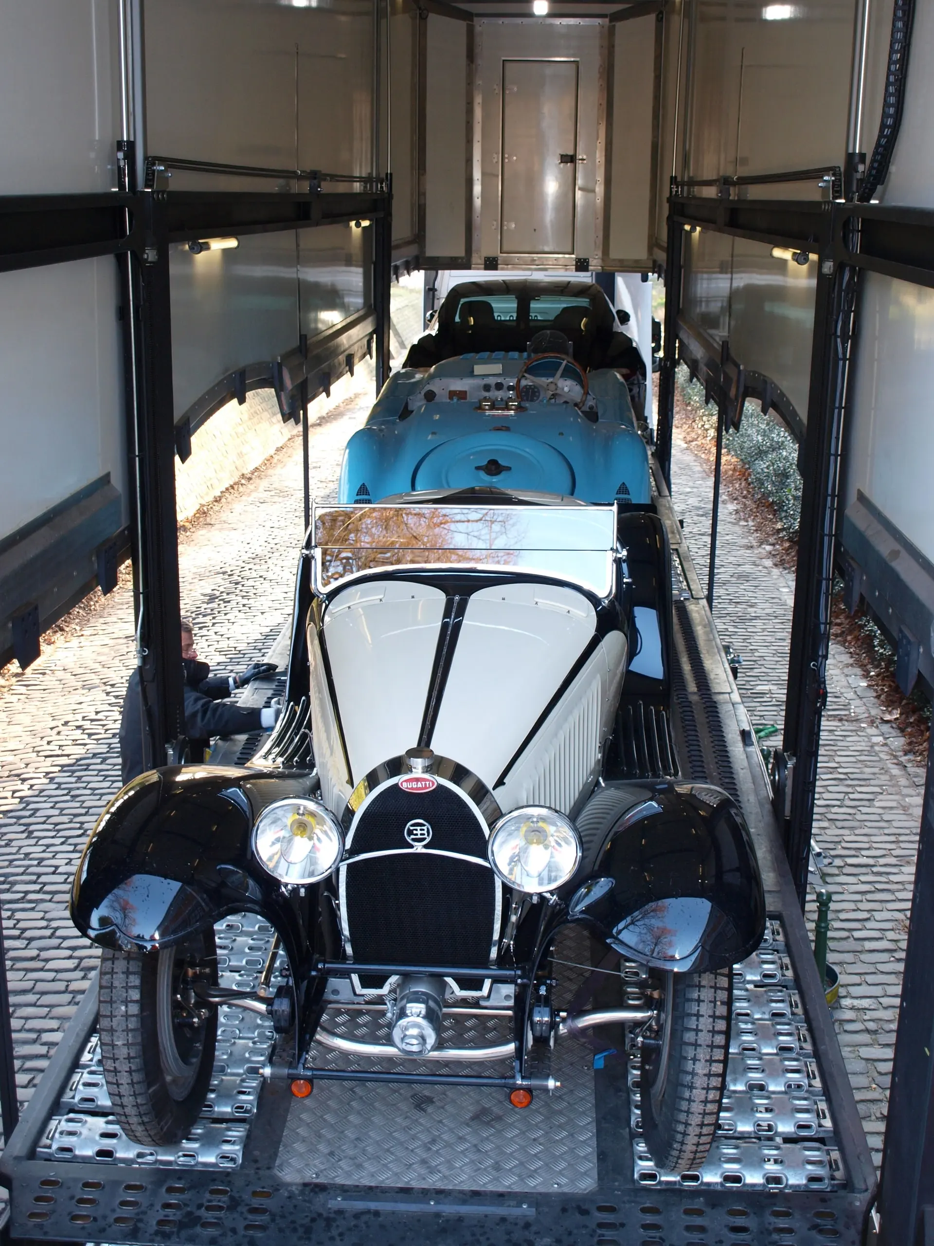 Bugatti de grand prix noire et Bugatti profilée bleue dans le camion