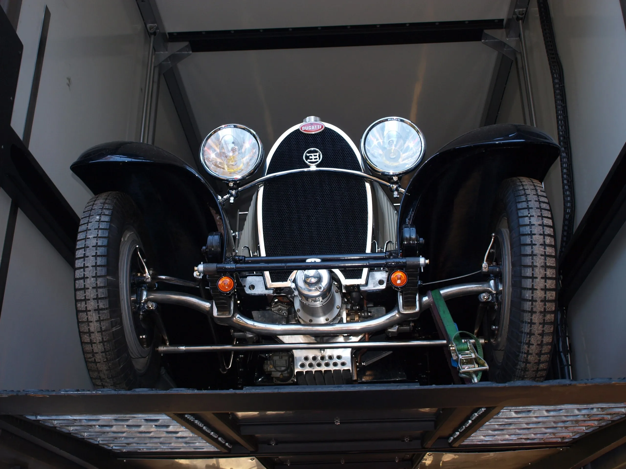 Voorzijde van een zwarte vooroorlogse Bugatti-grandprixwagen met dubbele windschermen