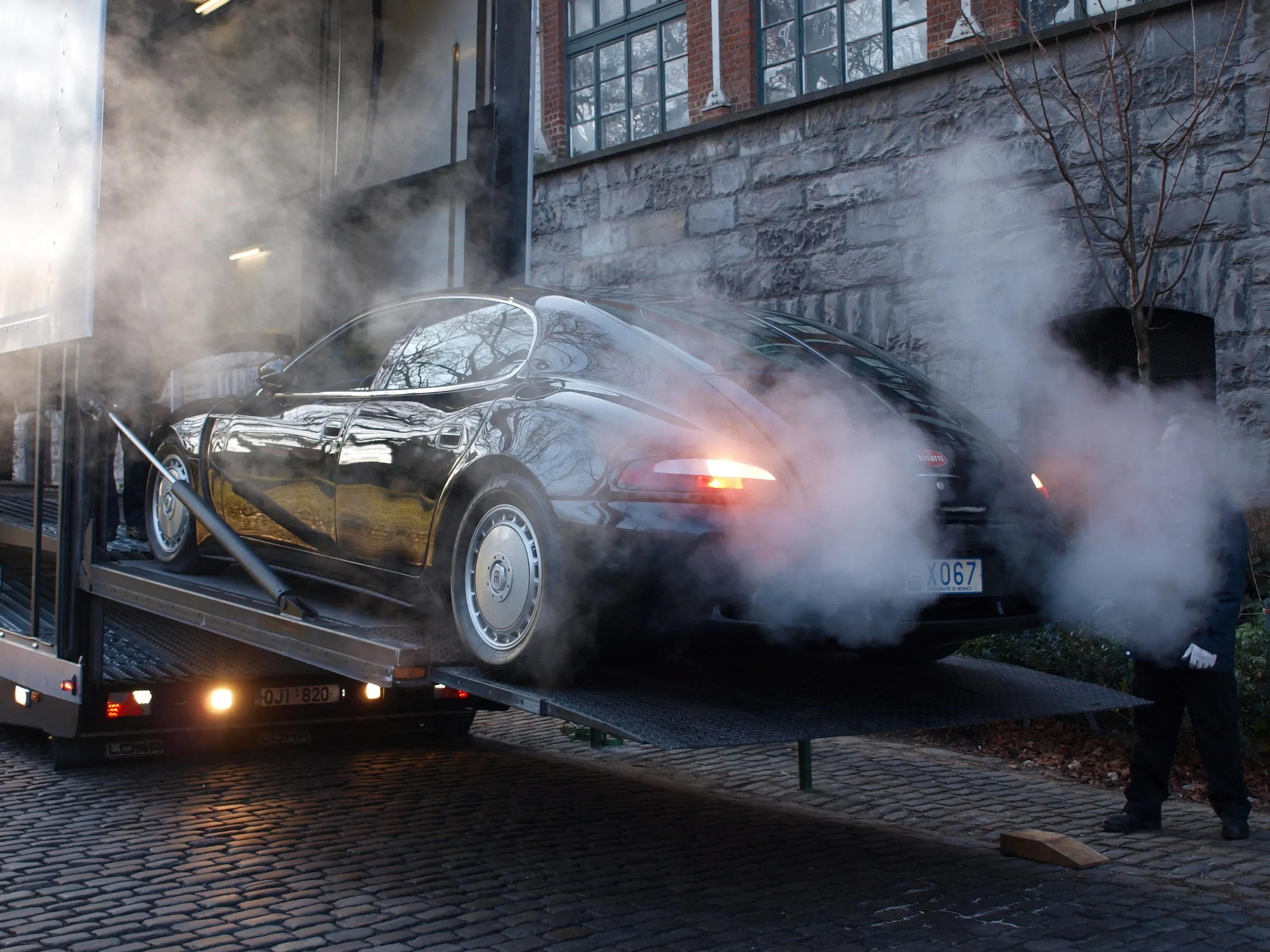 Laufender Vorkriegs-Bugatti auf der Rampe in der Dämmerung, Abgasrauch in der Luft