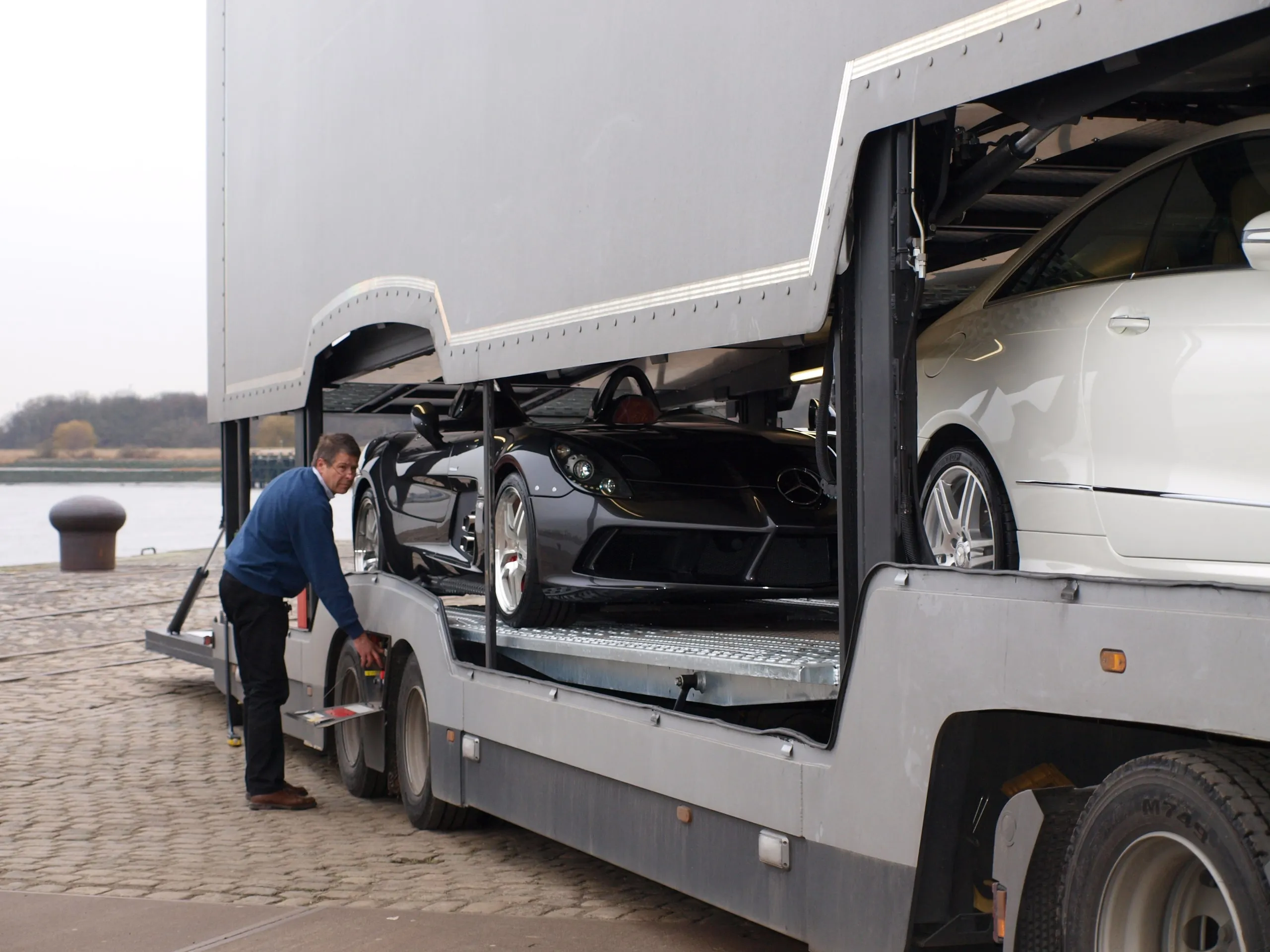 Crewlid controleert de banden onder een transporterdek op een Antwerpse kaai