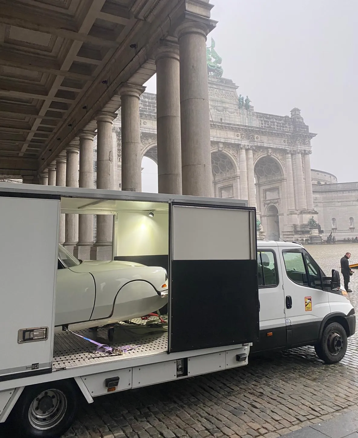 Witte Citroën DS in een kleine gesloten truck onder de zuilengang