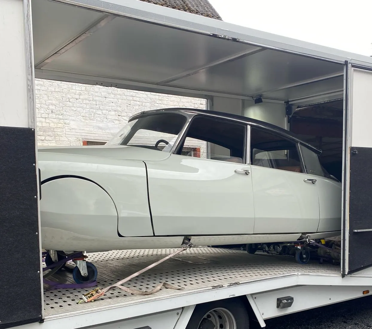 Witte Citroën DS geladen in een gesloten transporter voor een schuur