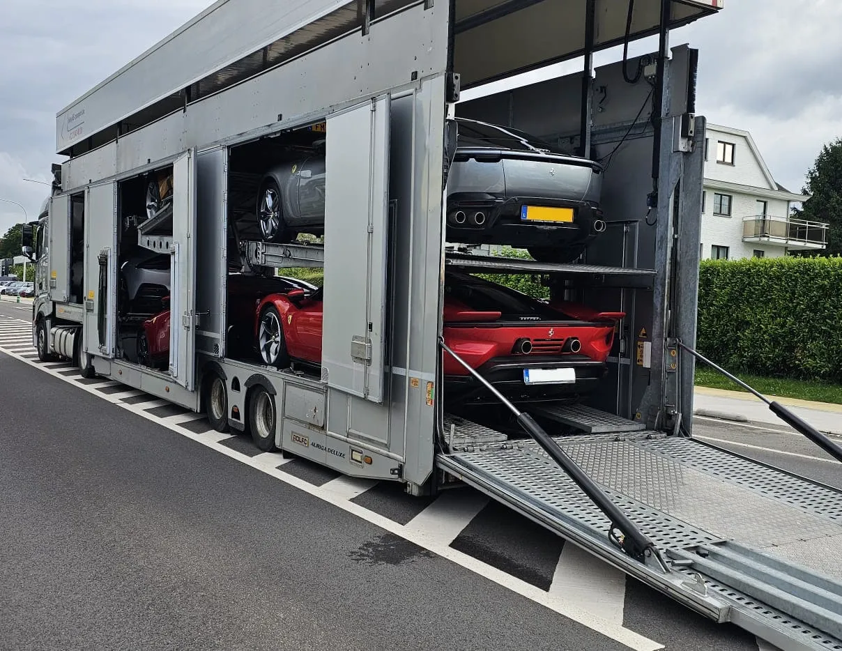 Autotransporter geladen met Ferrari's op een tweevaksweg