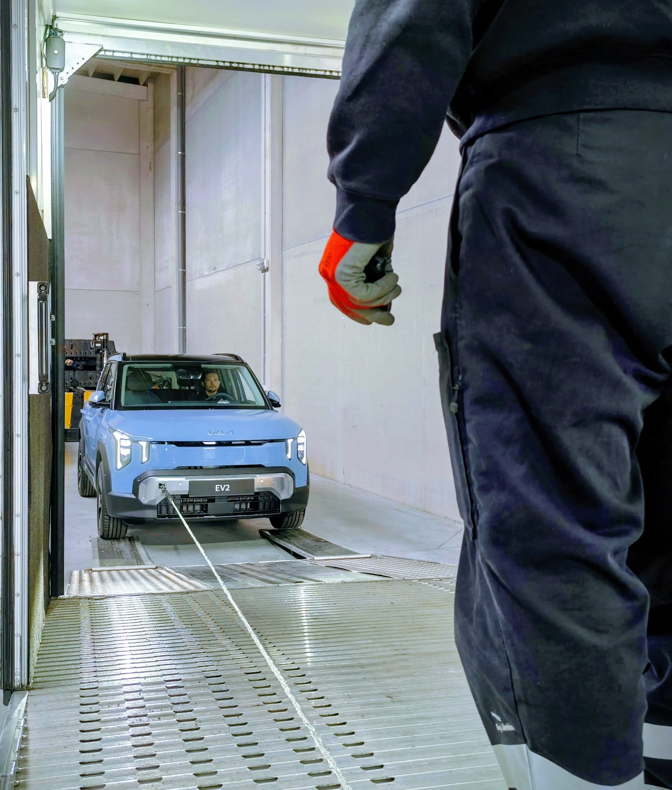 Medewerker met spanband tijdens het laden van een elektrische SUV