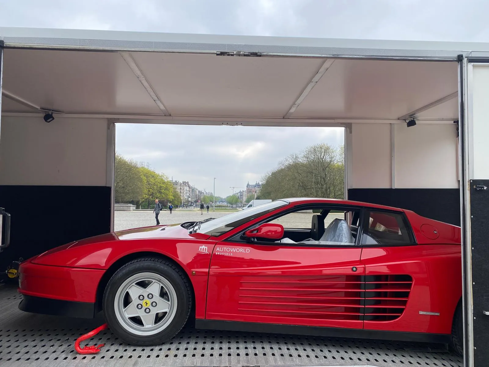 Rode Ferrari Testarossa in profiel, omlijst door beide open zijden