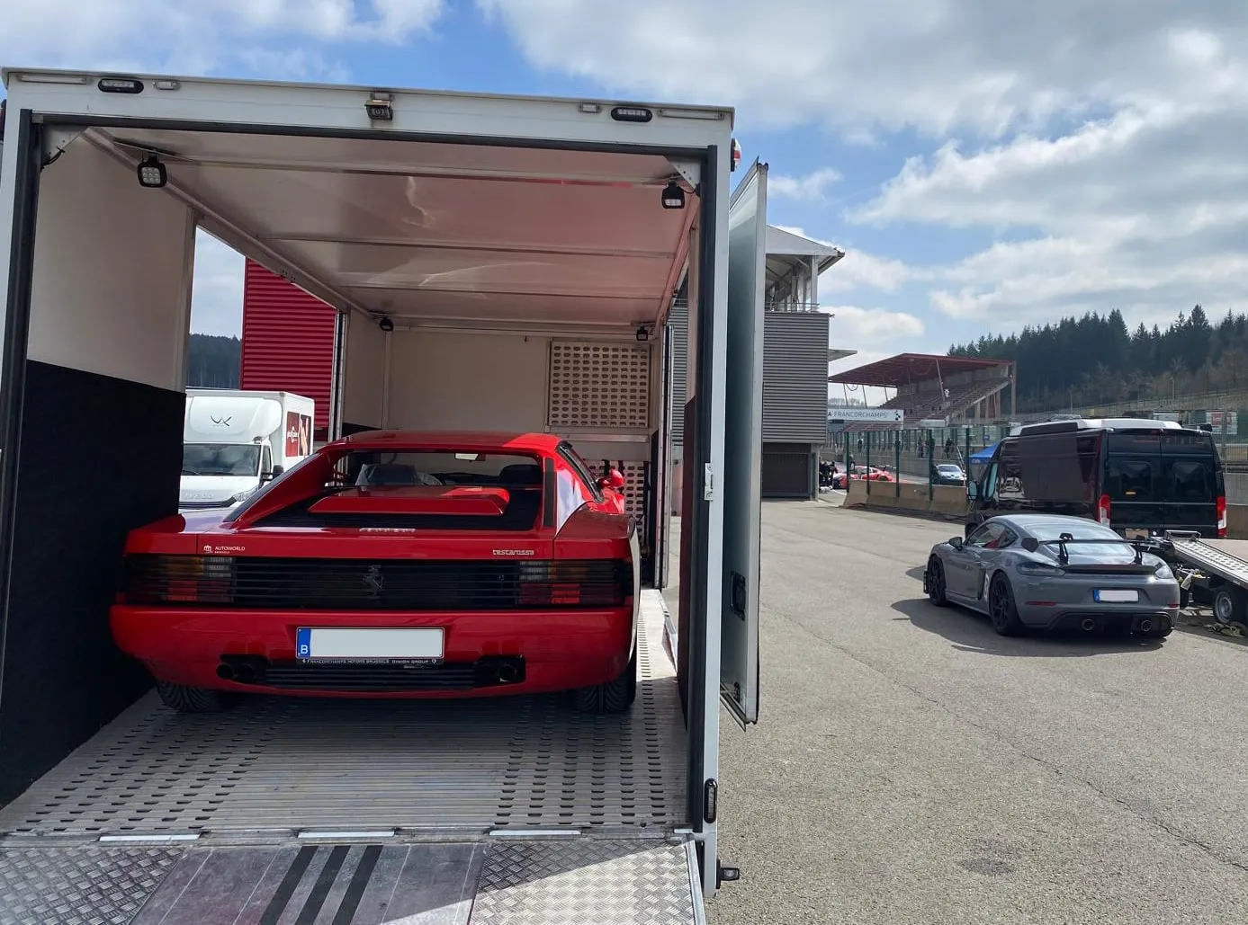Achterkant van een rode Ferrari Testarossa in de transporter op het circuit