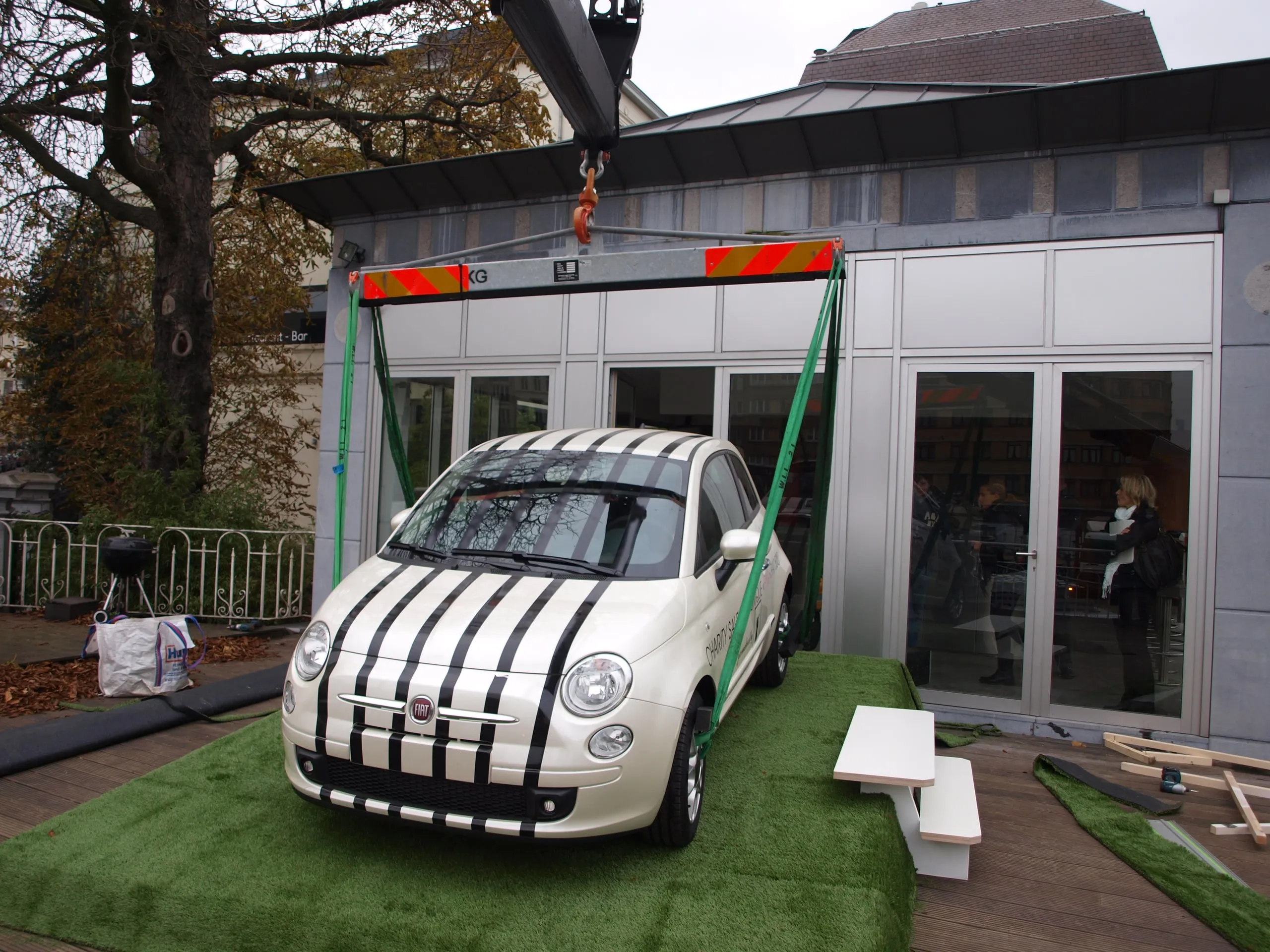 Fiat 500 met racestrepen neergezet op kunstgras voor een showroom