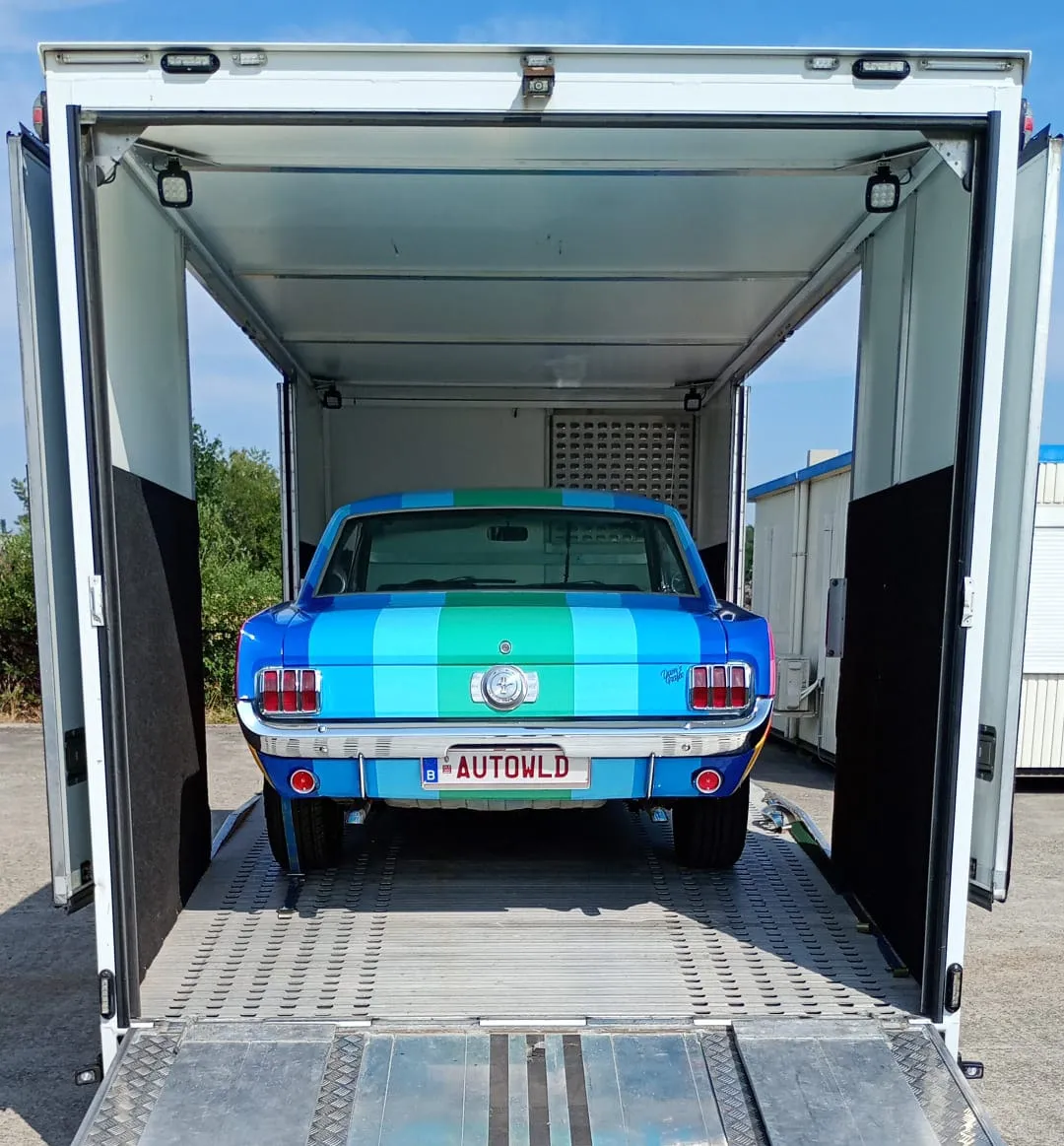 Achterzijde van een Ford Mustang art car in een gesloten transporter