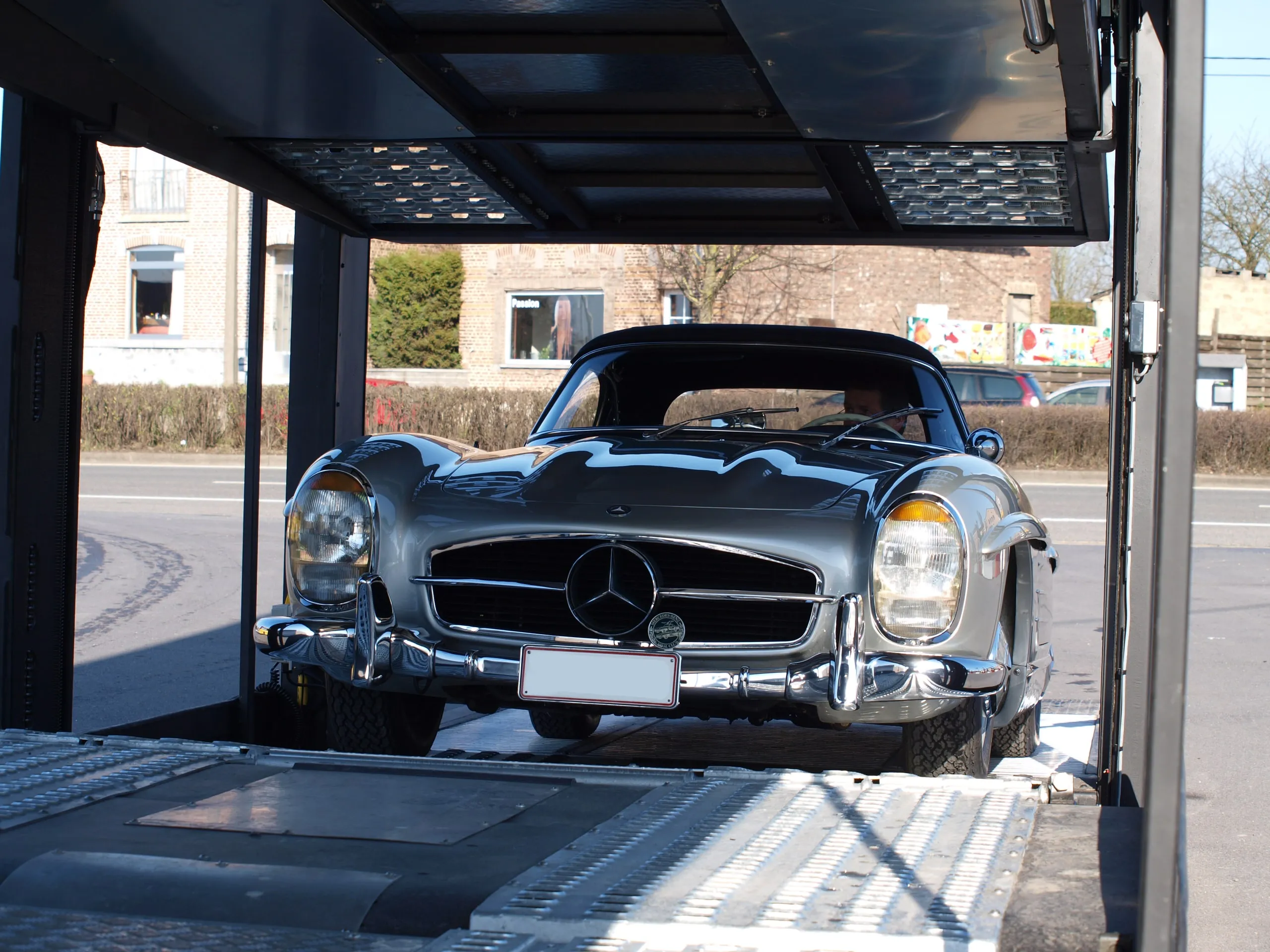 Mercedes 300 SL Gullwing omlijst door de open zijdeuren van een transporter