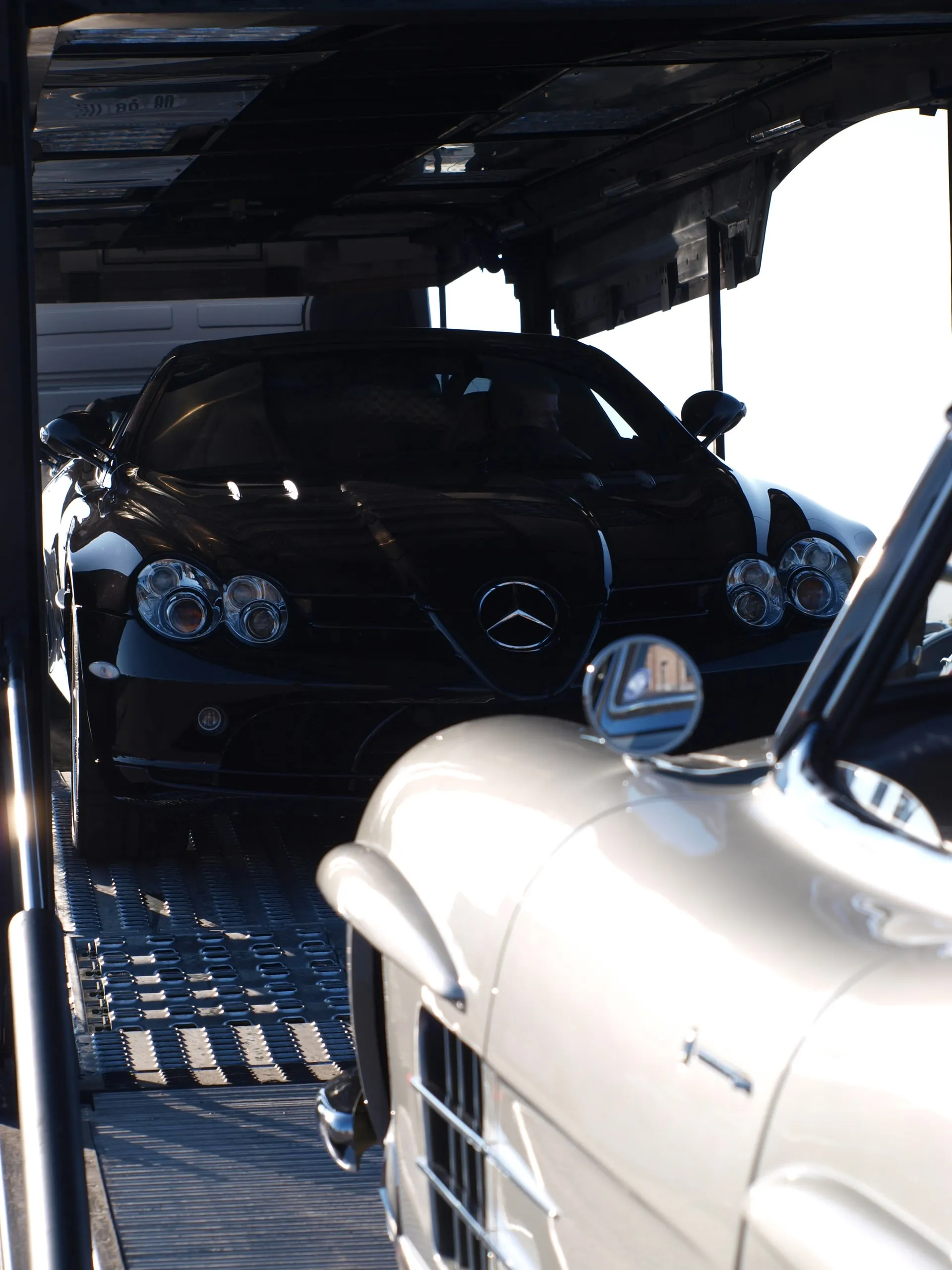 Neus van een Mercedes 300 SL Gullwing naast een moderne Mercedes op het dek
