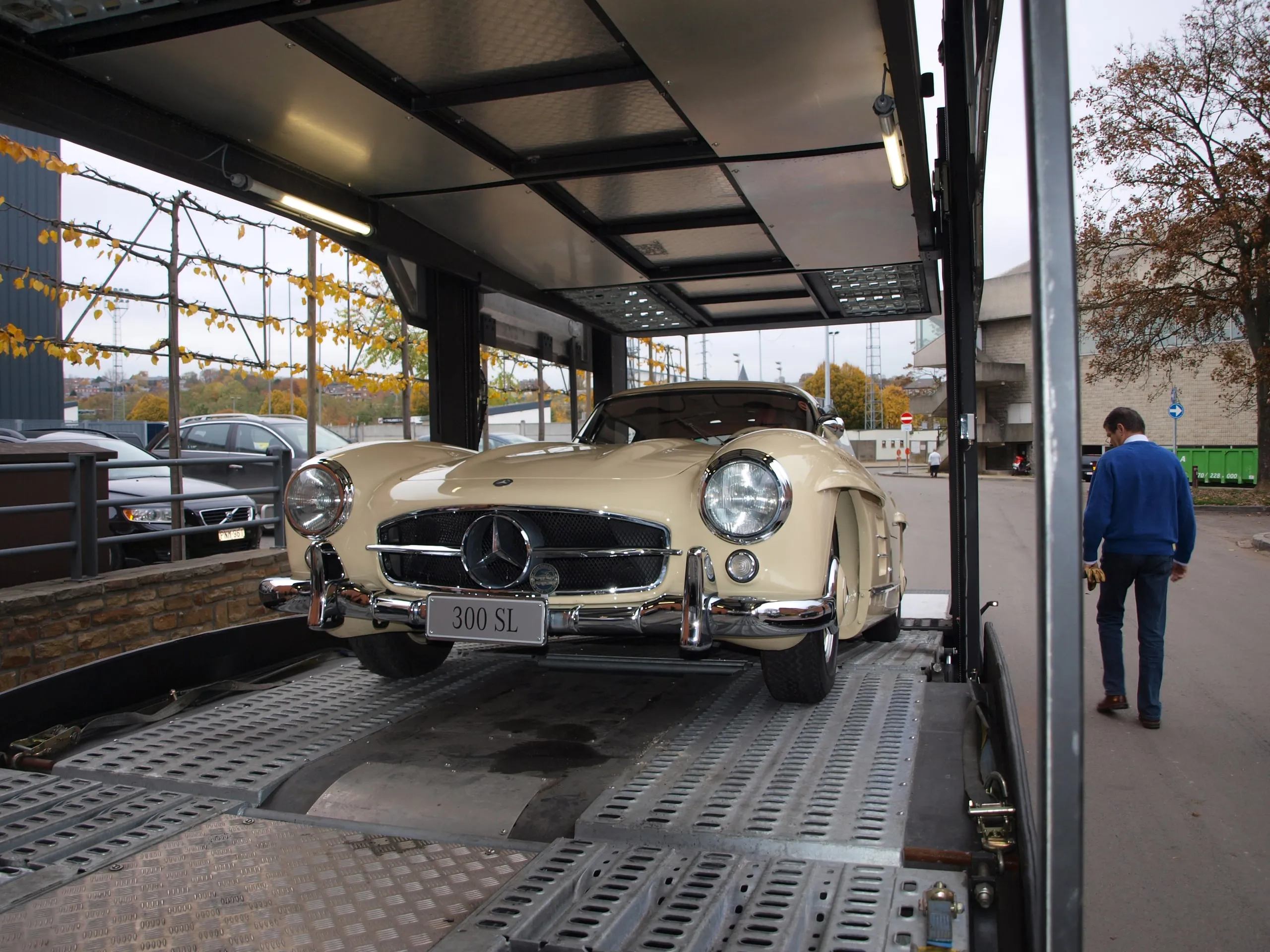 Crèmekleurige Mercedes 300 SL Gullwing op het onderdek, zijdeuren van de transporter open