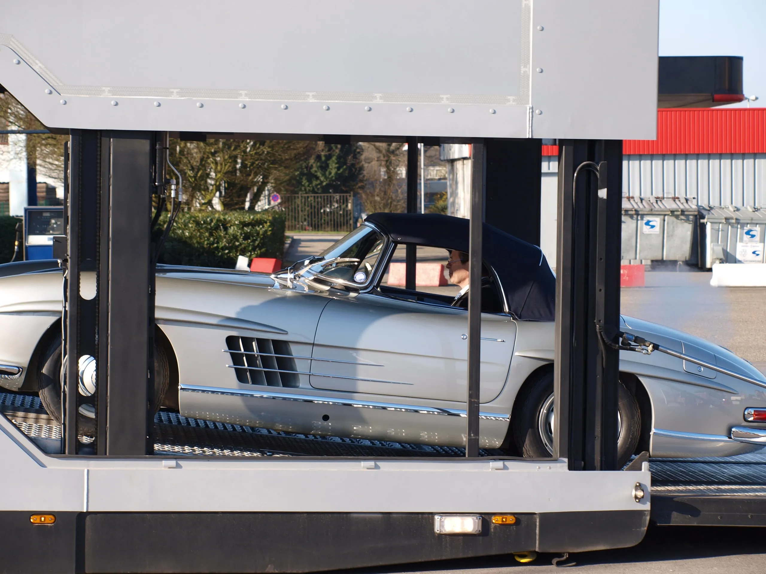 Zilverkleurige Mercedes 300 SL Gullwing gezien door de open flank van de transporter