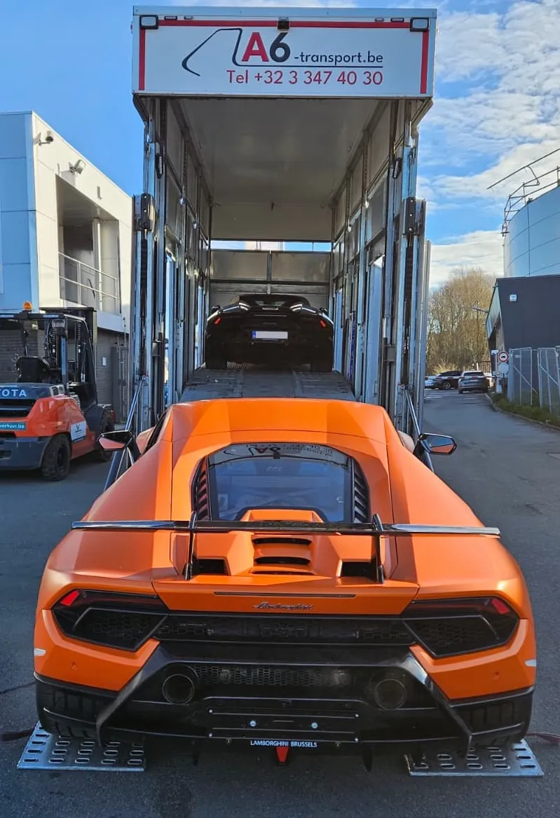 Oranje Lamborghini Huracán rijdt de platen van een transporter af