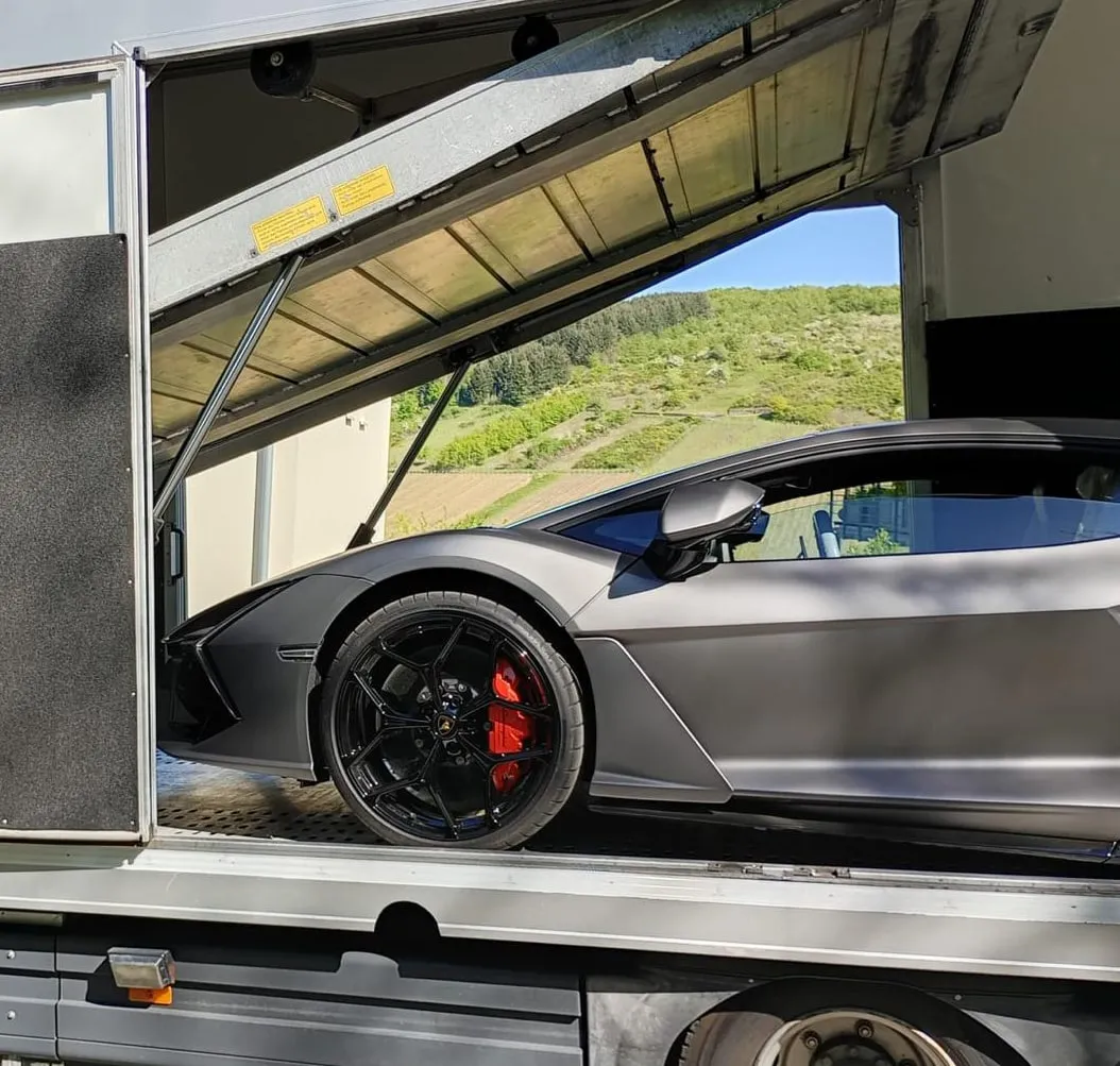 Lamborghini Revuelto gezien door de zijdeur van de transporter