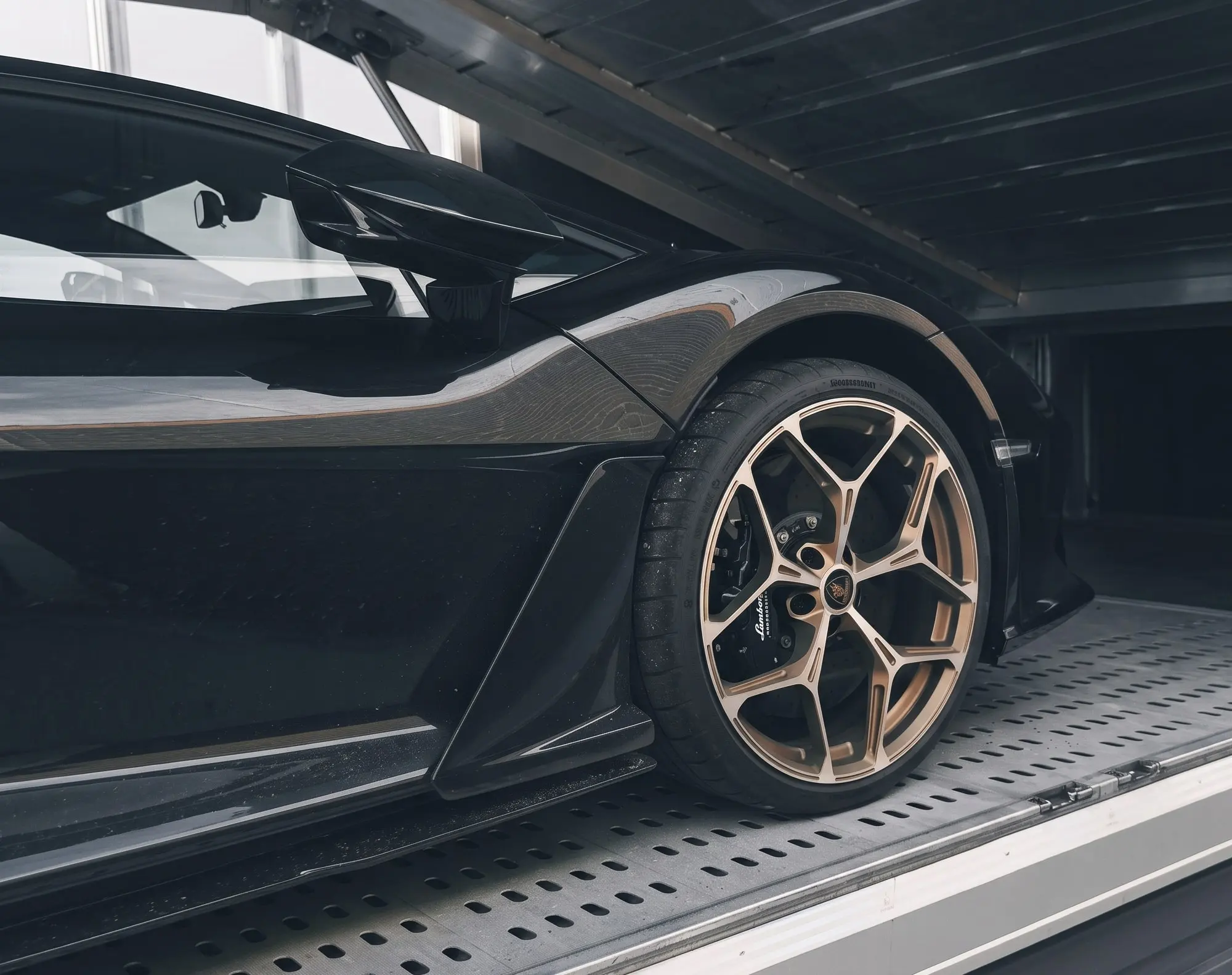 Lamborghini Revuelto negro bajo la plataforma superior de un camión