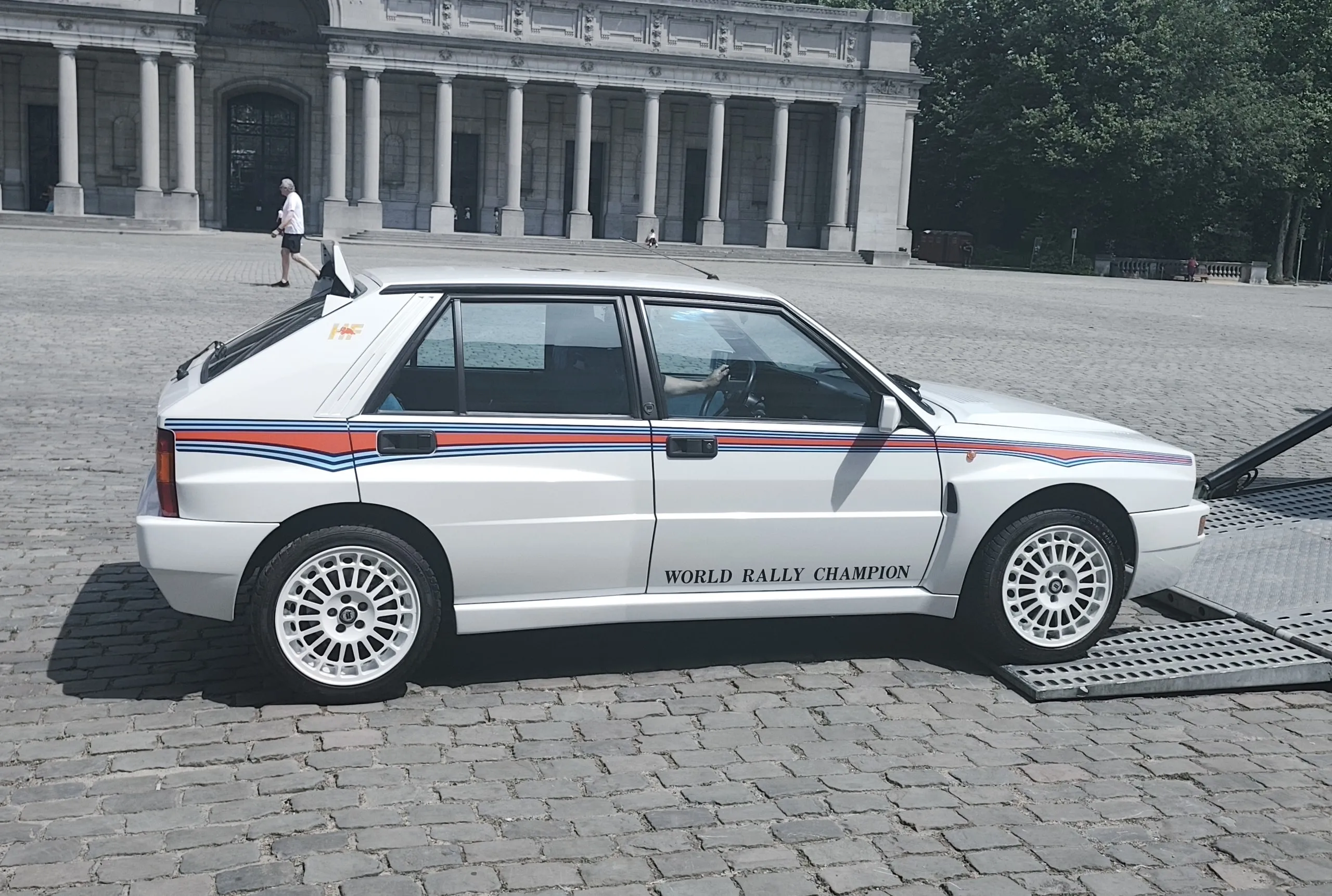 Lancia Delta Integrale de profil devant les colonnades du musée