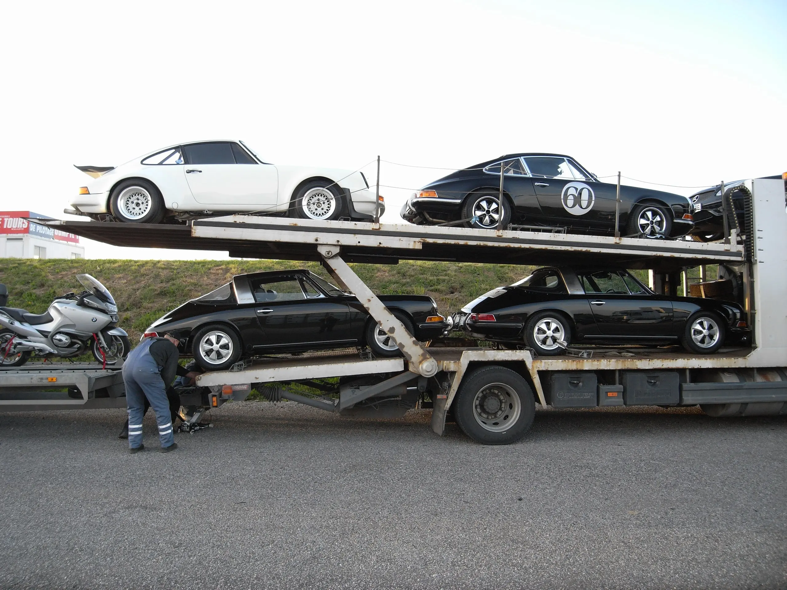 Équipe chargeant des Porsche 911 sur un camion à la fin d'une journée de piste