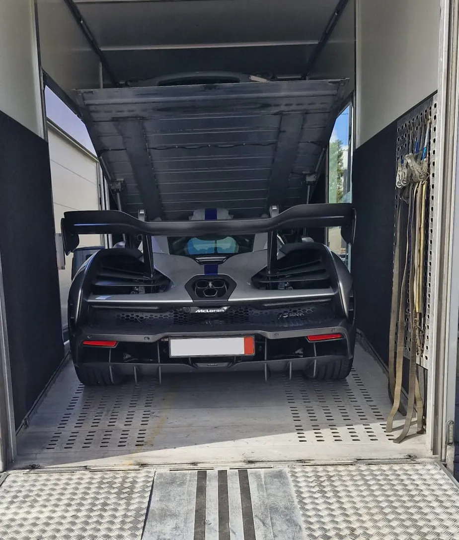 Achterkant van een McLaren Senna midden in de gesloten transporter
