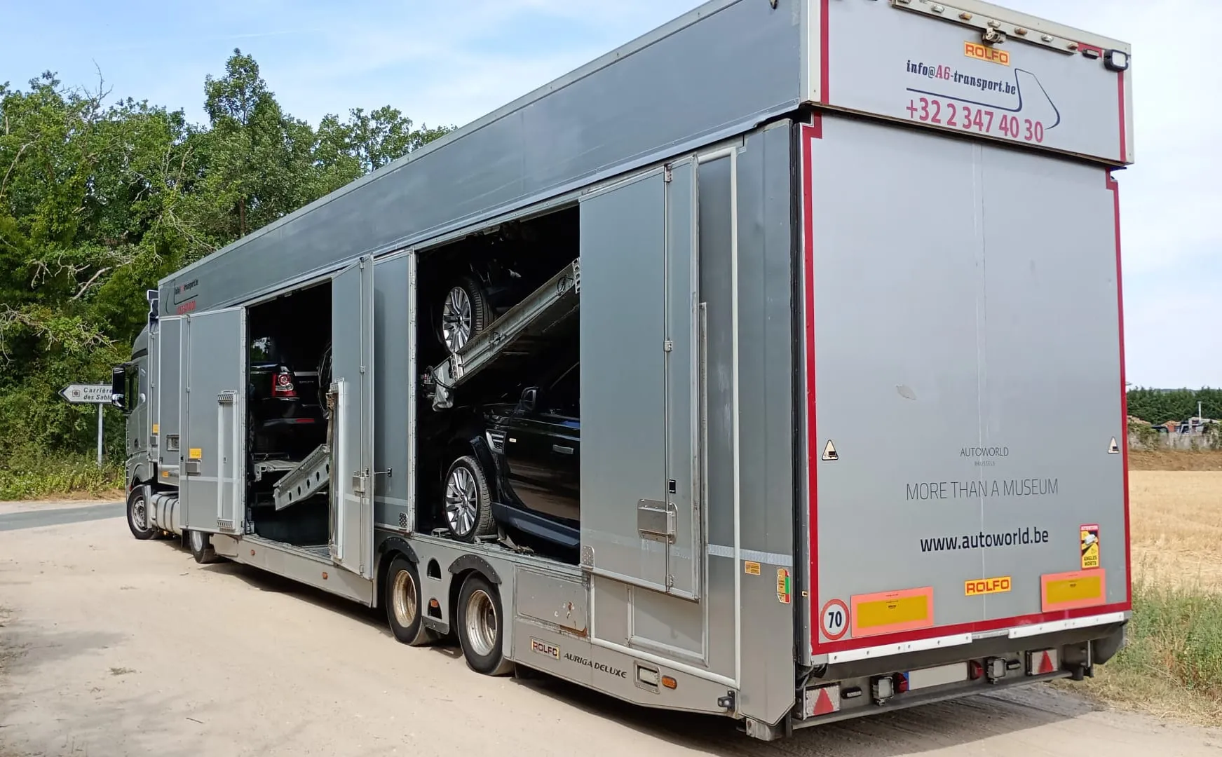 Camion porte-voitures multi-ponts sur un chemin de campagne