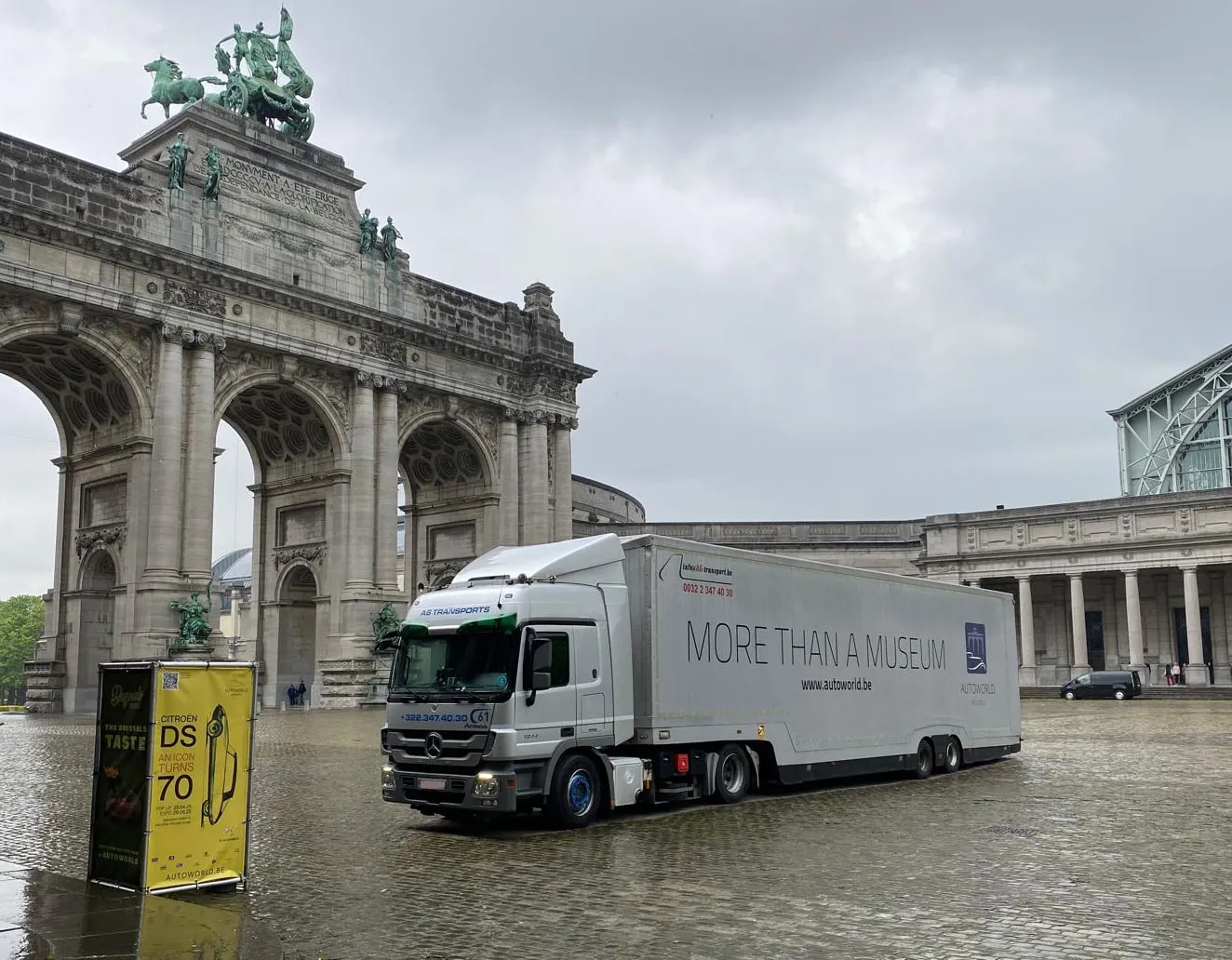 Museumtransporter onder de triomfboog van het Jubelpark in de regen