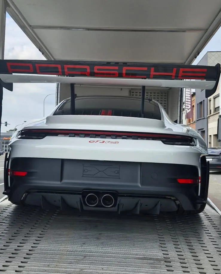 Achtervleugel van een Porsche 911 GT3 RS onder het dak van de transporter