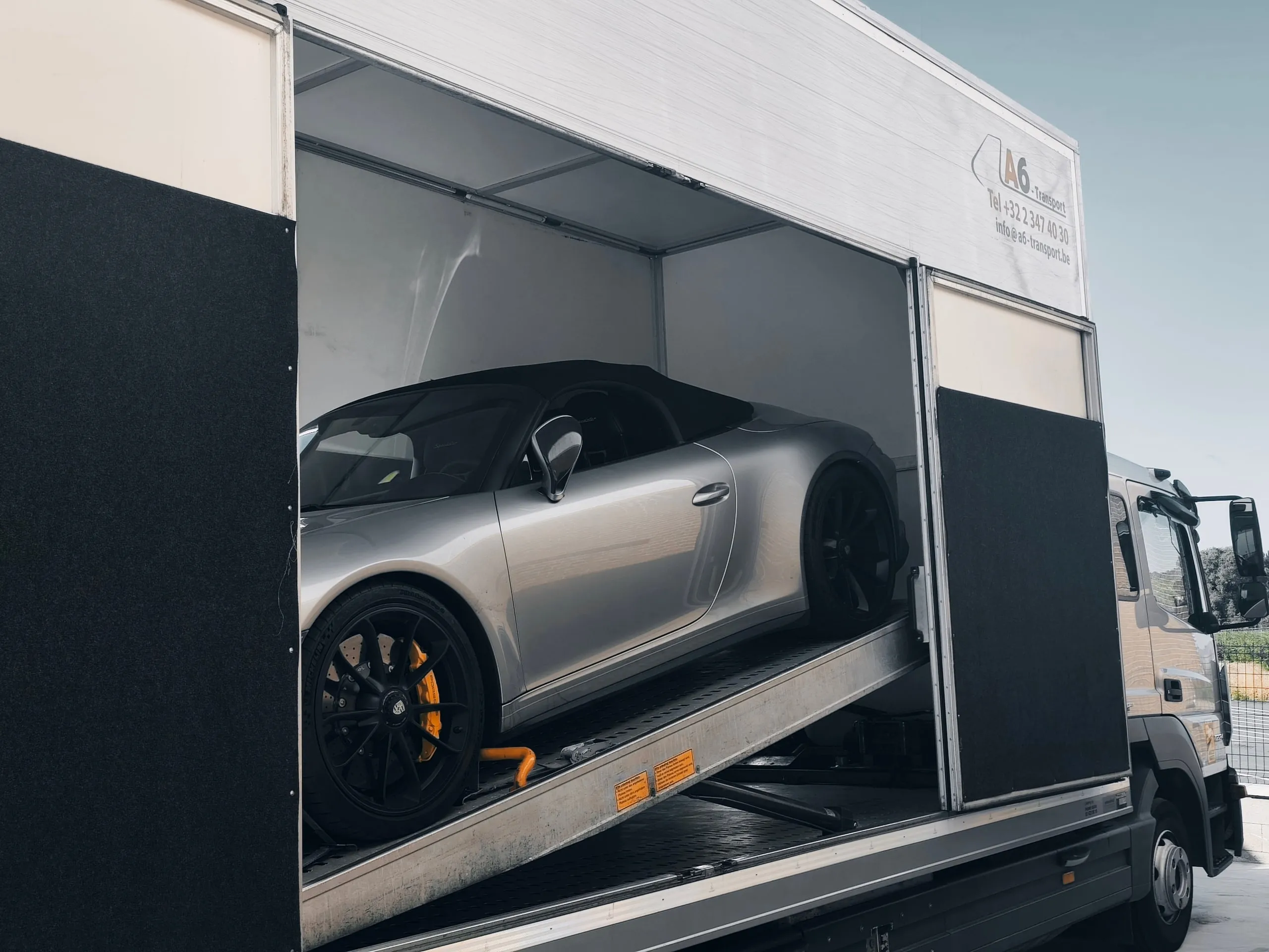 Zilveren Porsche 911 Speedster in een gesloten transporter