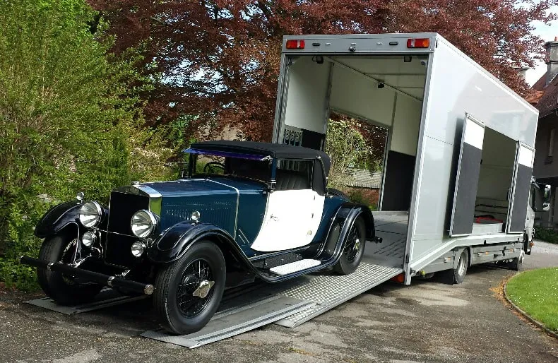 Vooroorlogse cabriolet geladen in een transporter op een oprit