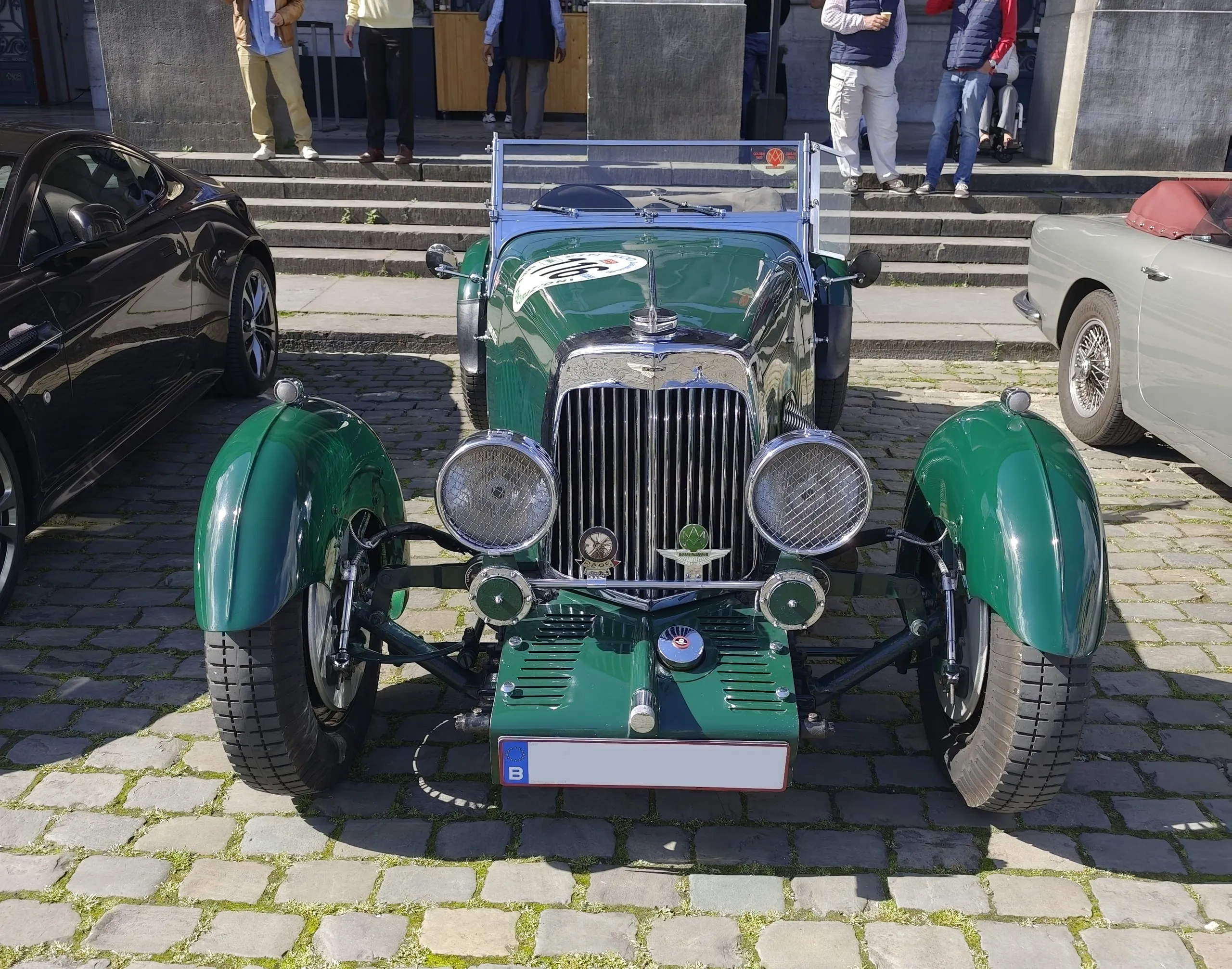 Groene vooroorlogse sportwagen voor de trappen van het museum