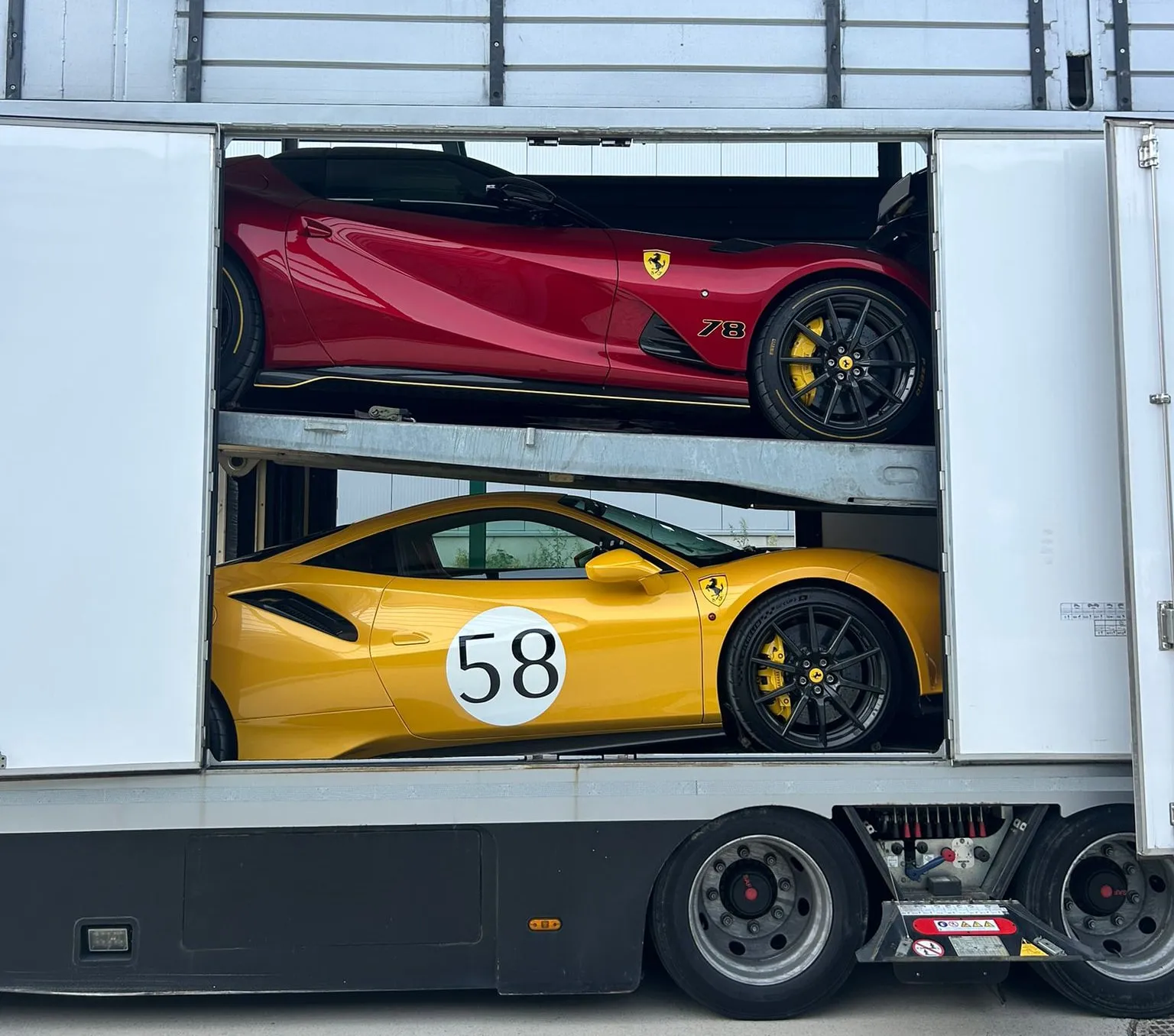 Rode Ferrari met nummer 78 op het bovendek, gele Ferrari 488 Pista met nummer 58 eronder