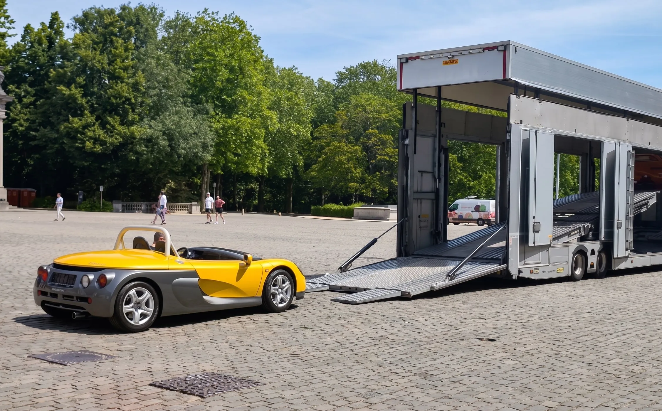 Gele Renault Sport Spider naast een autotransporter