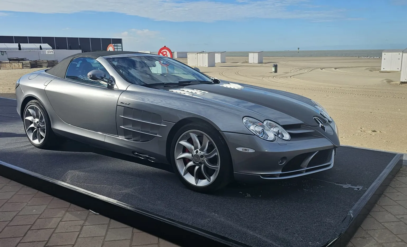 Mercedes SLR McLaren roadster op een podium naast het strand