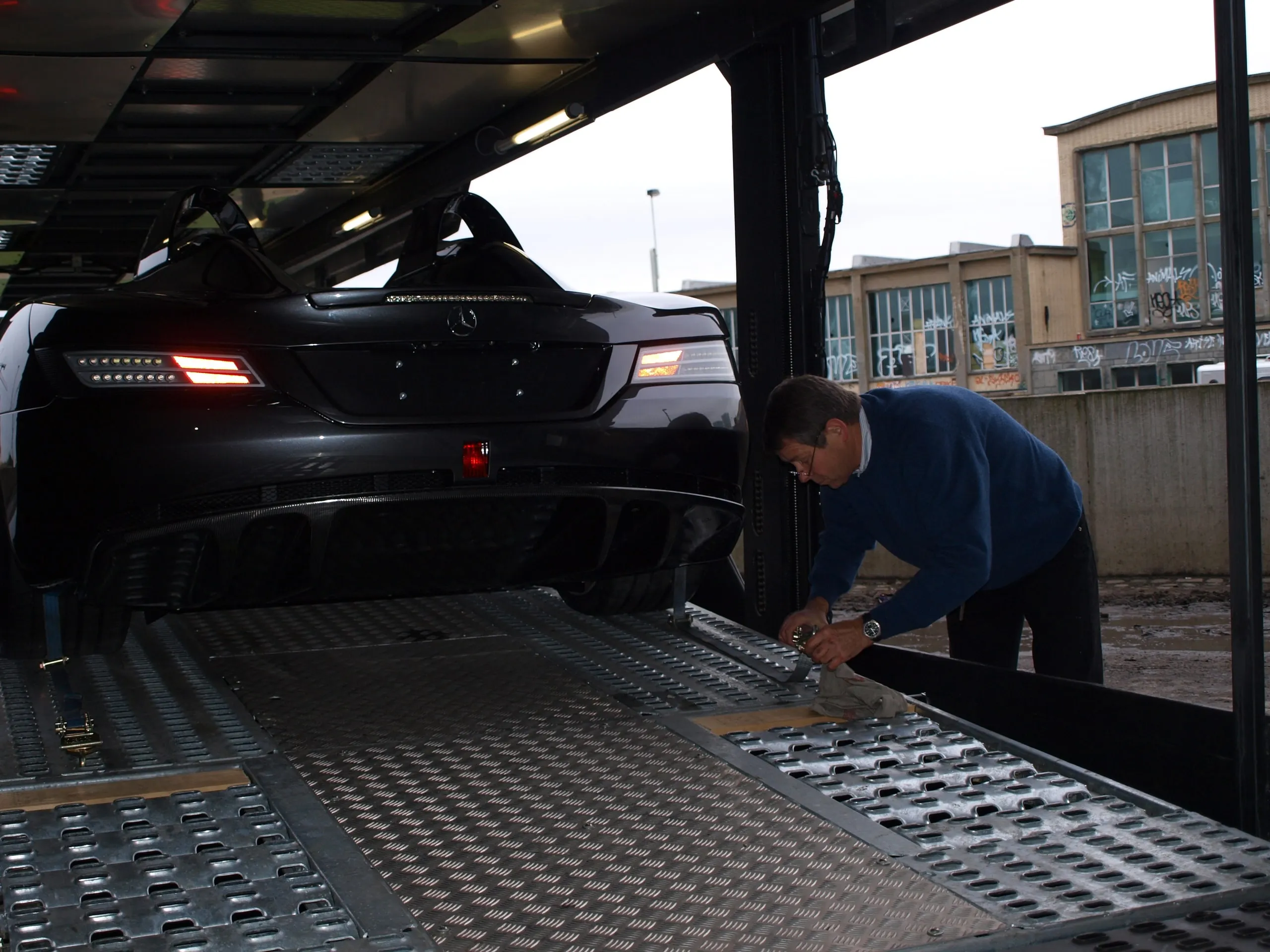 Crewlid spant een band op een Mercedes SLR McLaren op het onderdek