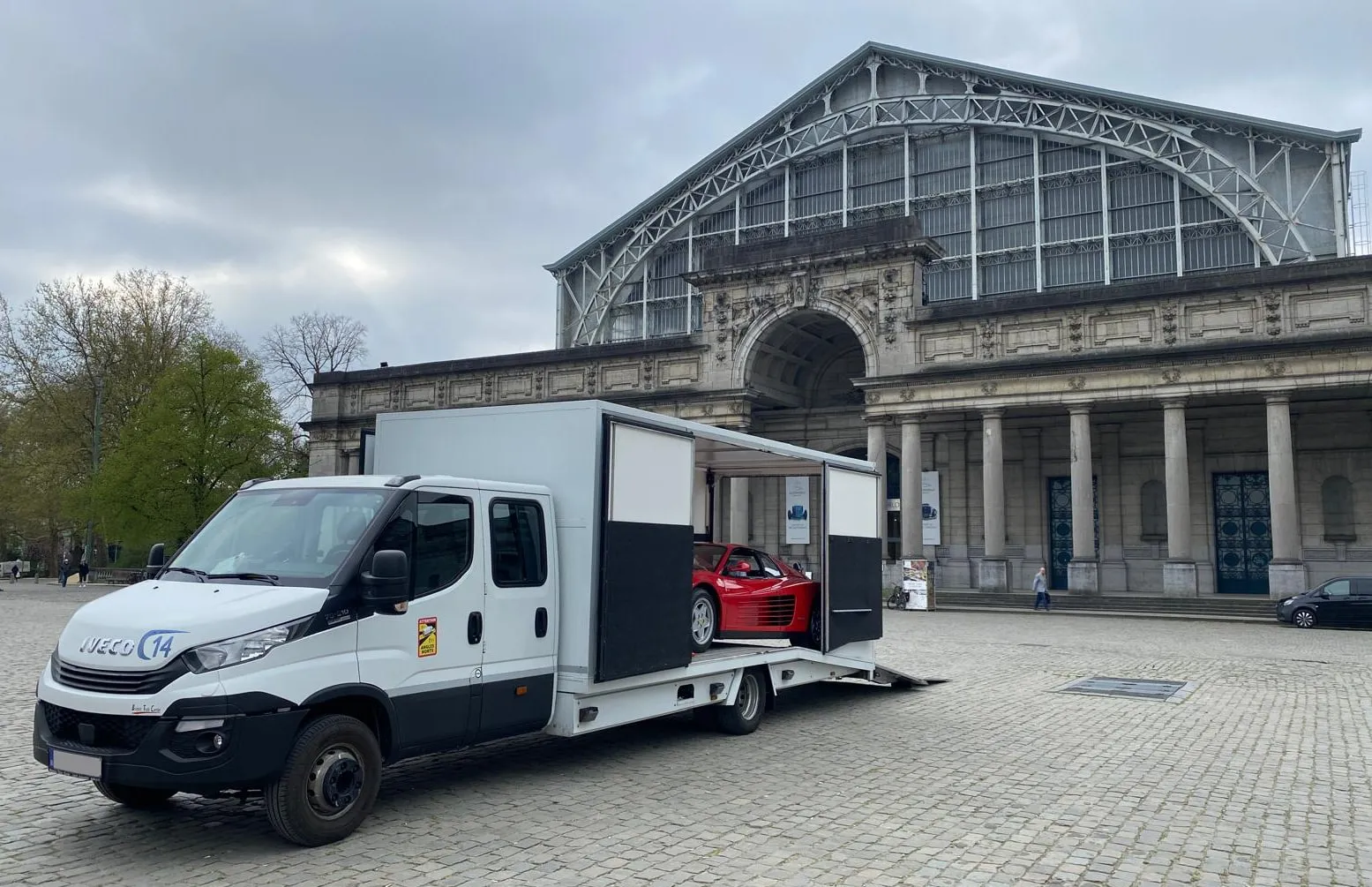 Rode Ferrari Testarossa in een kleine gesloten truck voor de hallen
