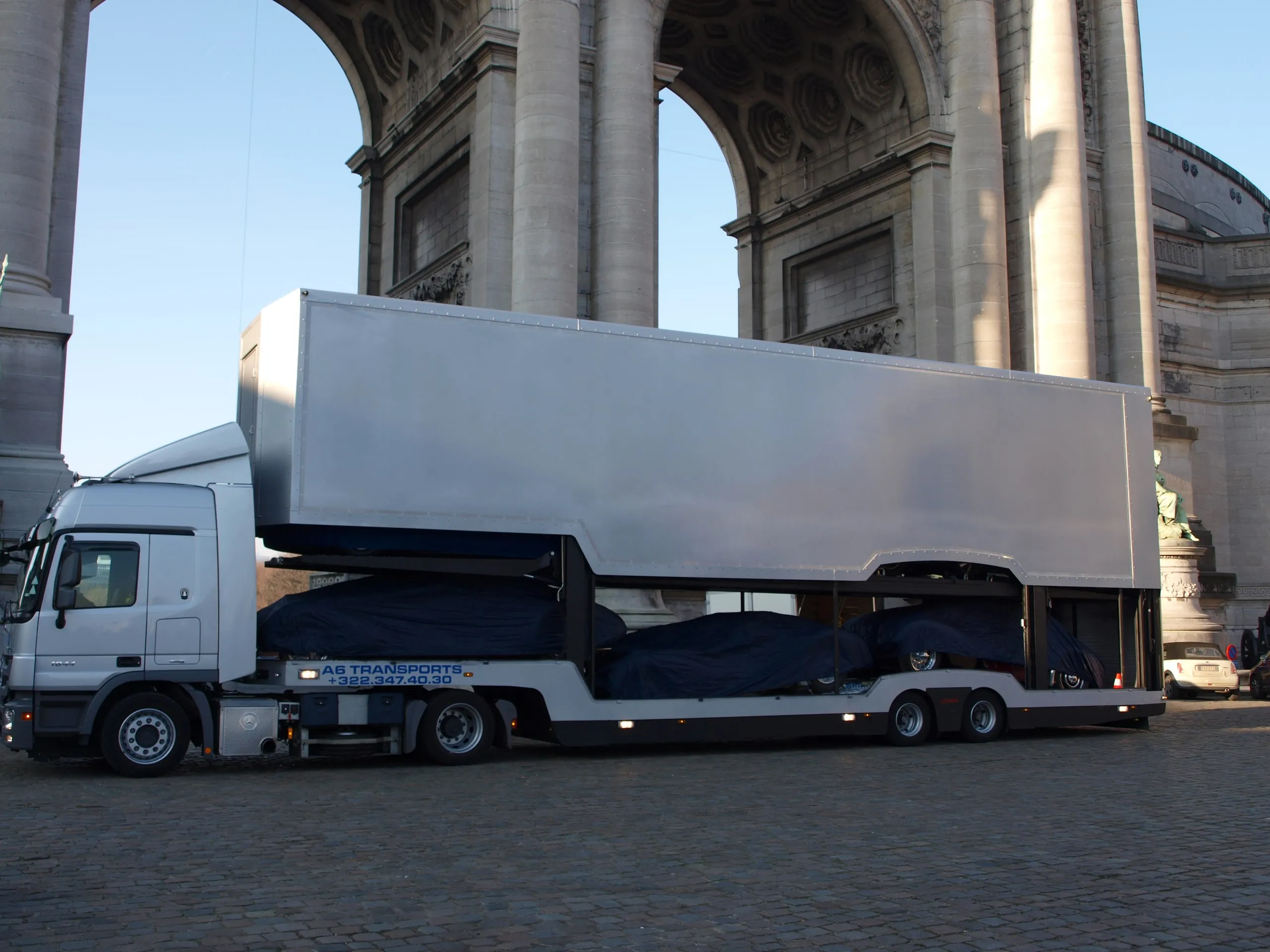 Vollständig geschlossener Transporter unter dem Cinquantenaire-Bogen, Autos unter Abdeckungen