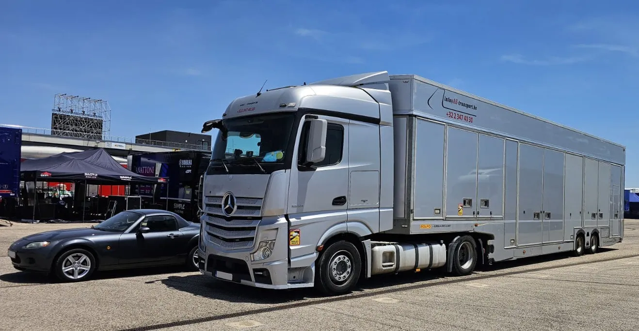 Gesloten transporter geparkeerd in een circuitpaddock