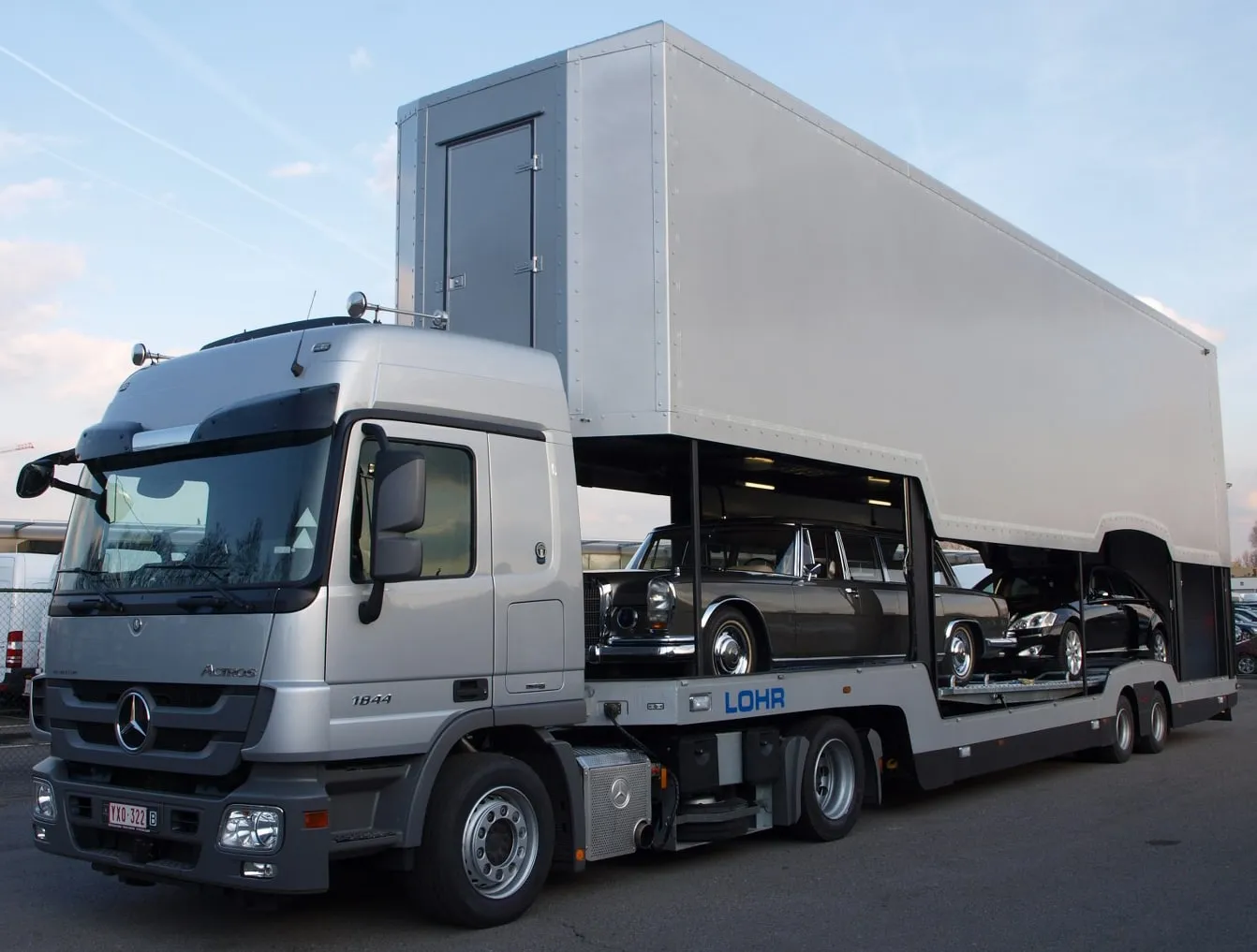 Gesloten transporter geladen met klassieke Mercedessen, vooraanzicht