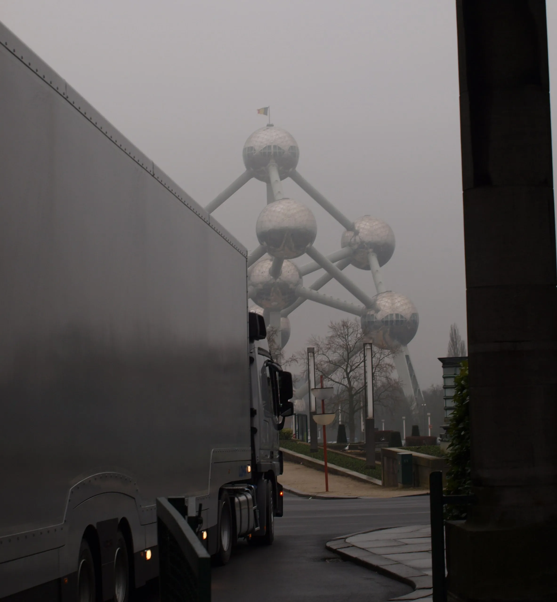 Geladen transporter rijdt in de mist langs het Atomium