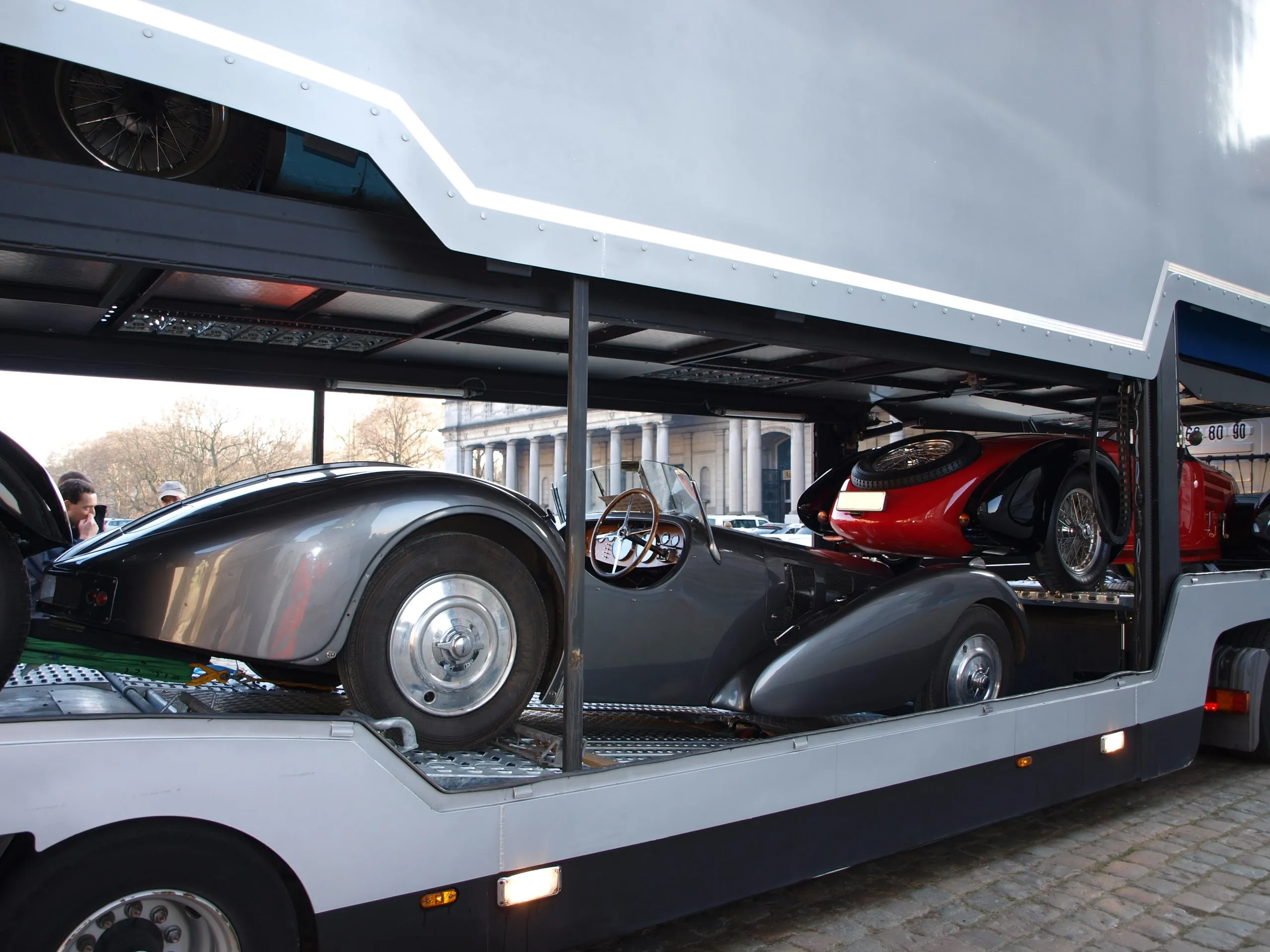 Zwei Vorkriegs-Bugatti auf beiden Decks, gesehen durch die offene Flanke des Lkw