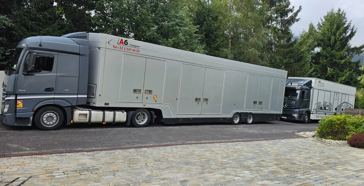 Zwei geschlossene Transporter nebeneinander auf gepflastertem Bergvorplatz