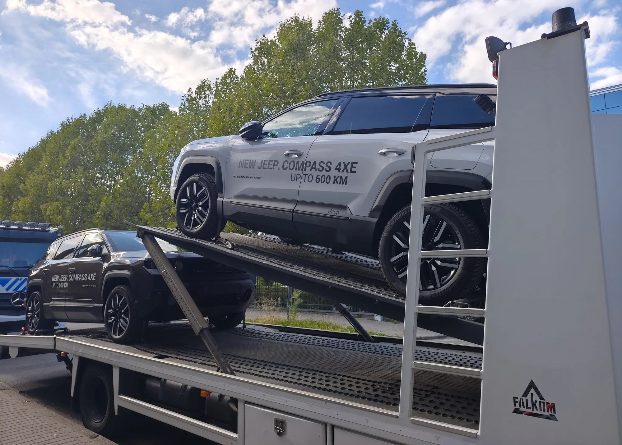Dos Jeep Compass 4xe en un camión plataforma, uno en el nivel inclinado y otro debajo