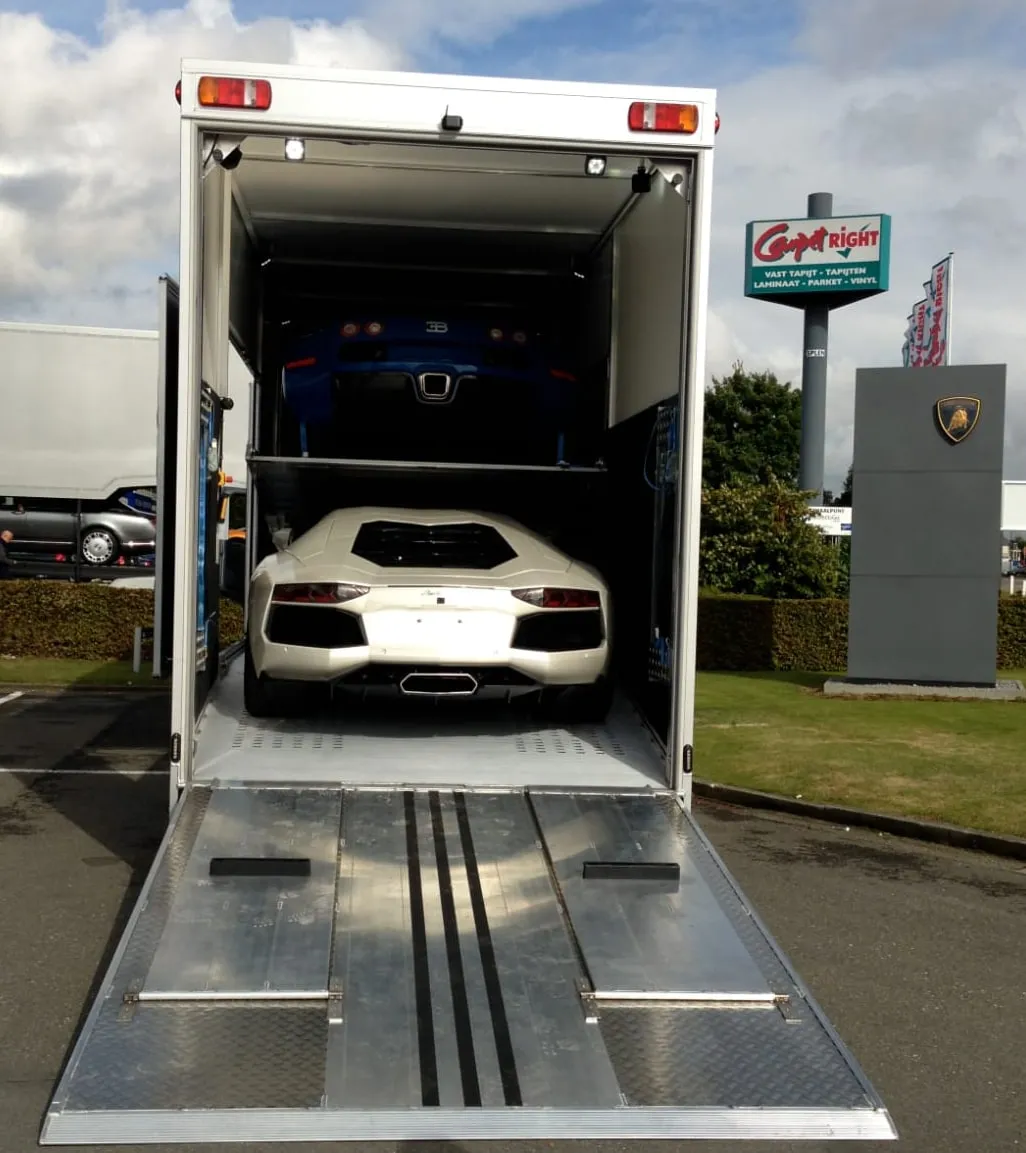 Twee witte Lamborghini's in een gesloten transporter voor een concessie